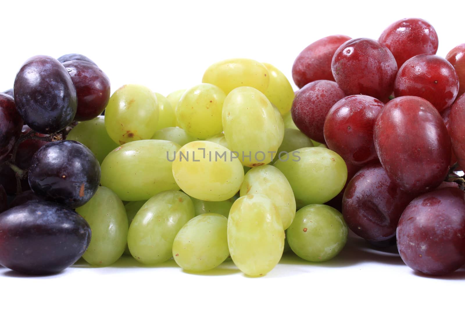 Three different types of grapes in red, green and black