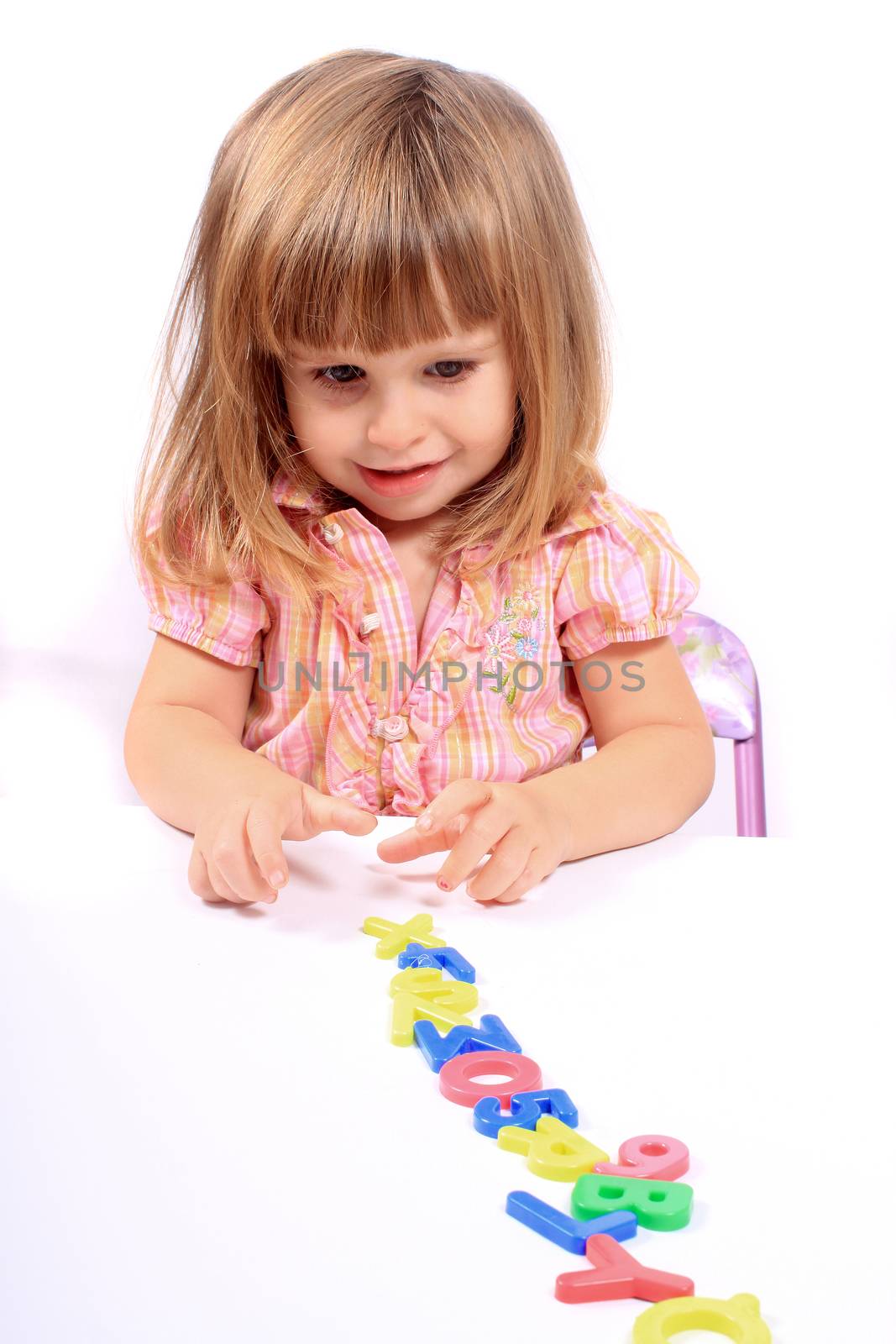 Young girl playing with letters and numbers for early childhood development