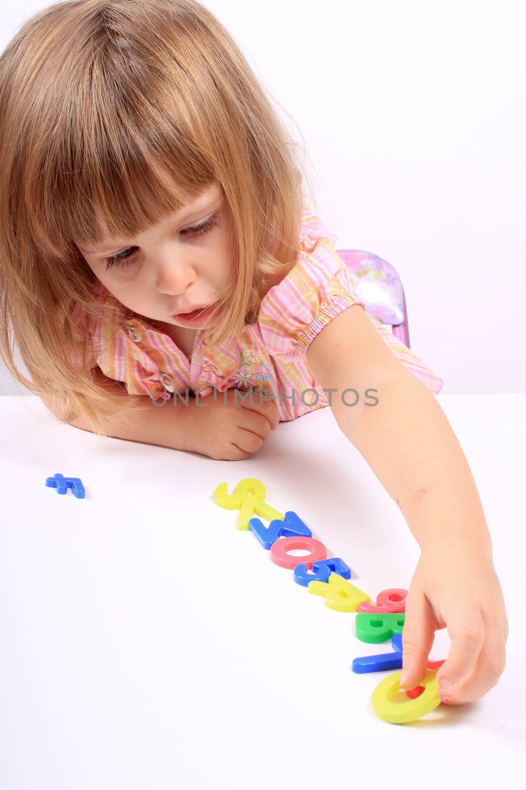 Young girl playing with letters and numbers for early childhood development