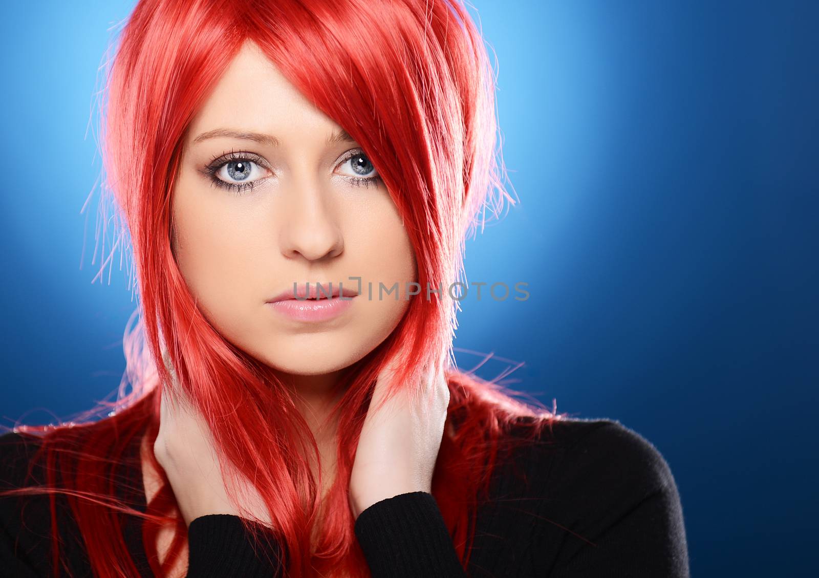 Beautiful red haired woman posing over blue background