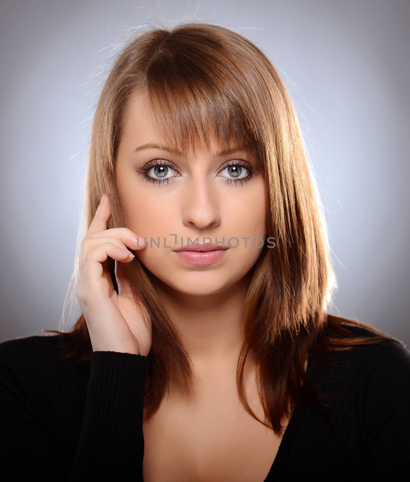 Beautiful brown haired woman posing over grey background