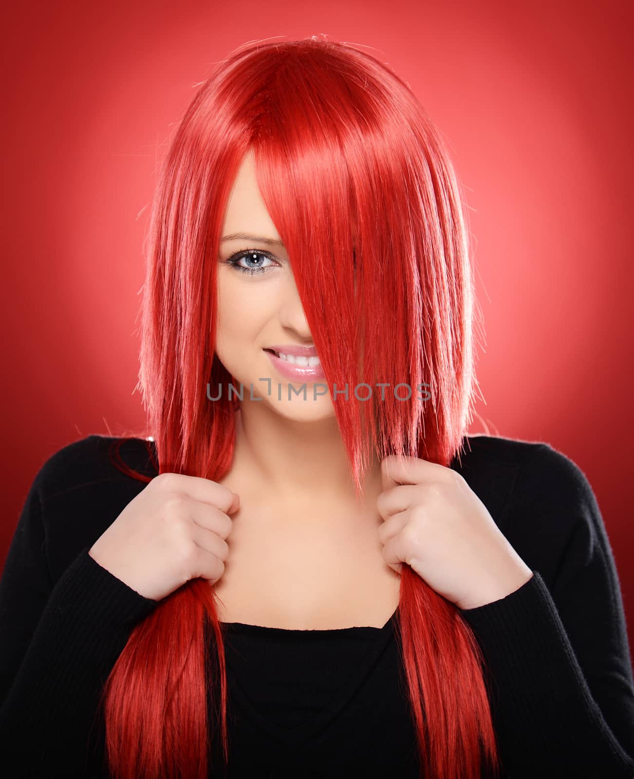 Beautiful red haired woman posing over red background