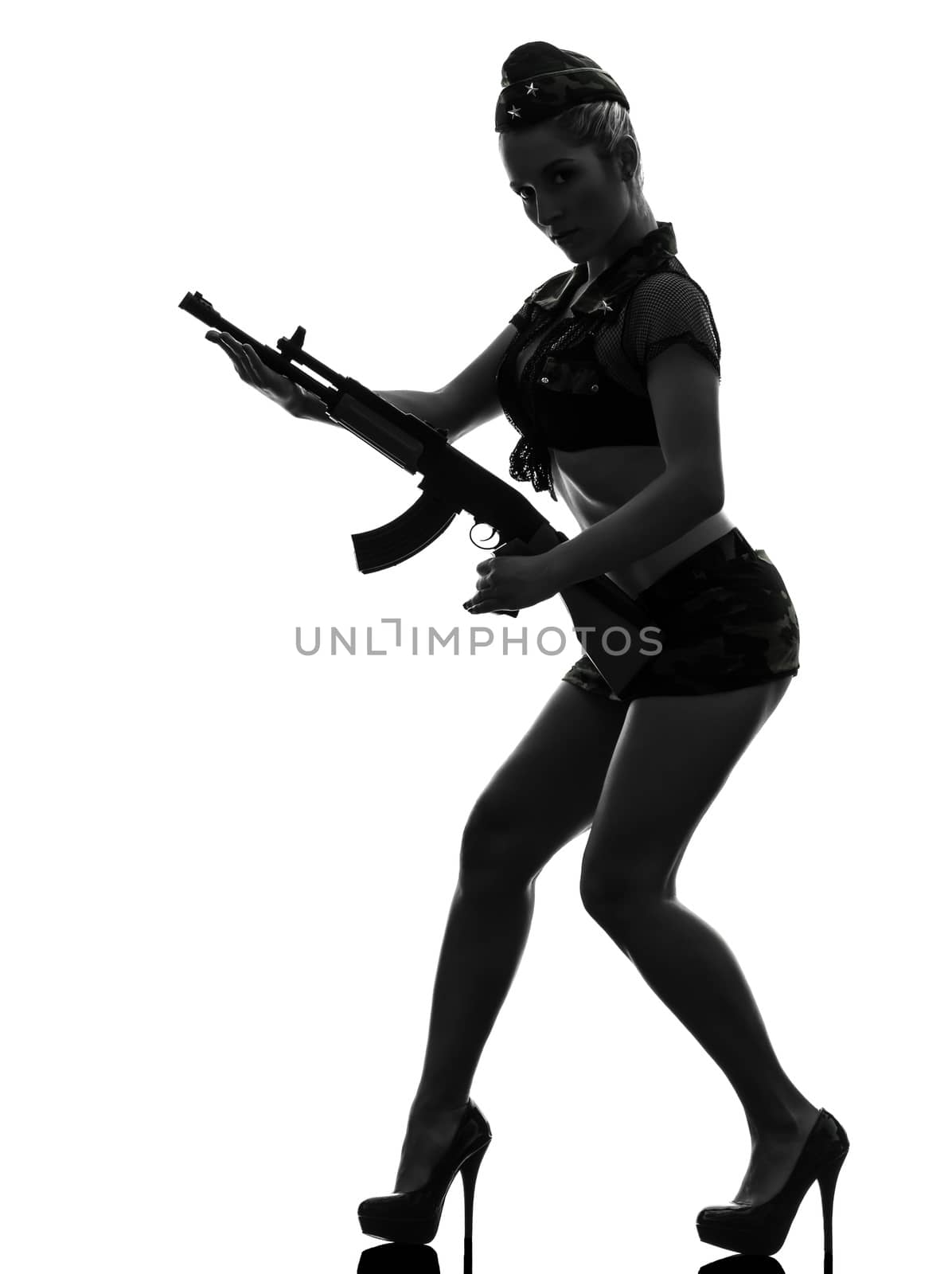one caucasian sexy woman in army uniform holding kalachnikov in silhouette studio isolated on white background