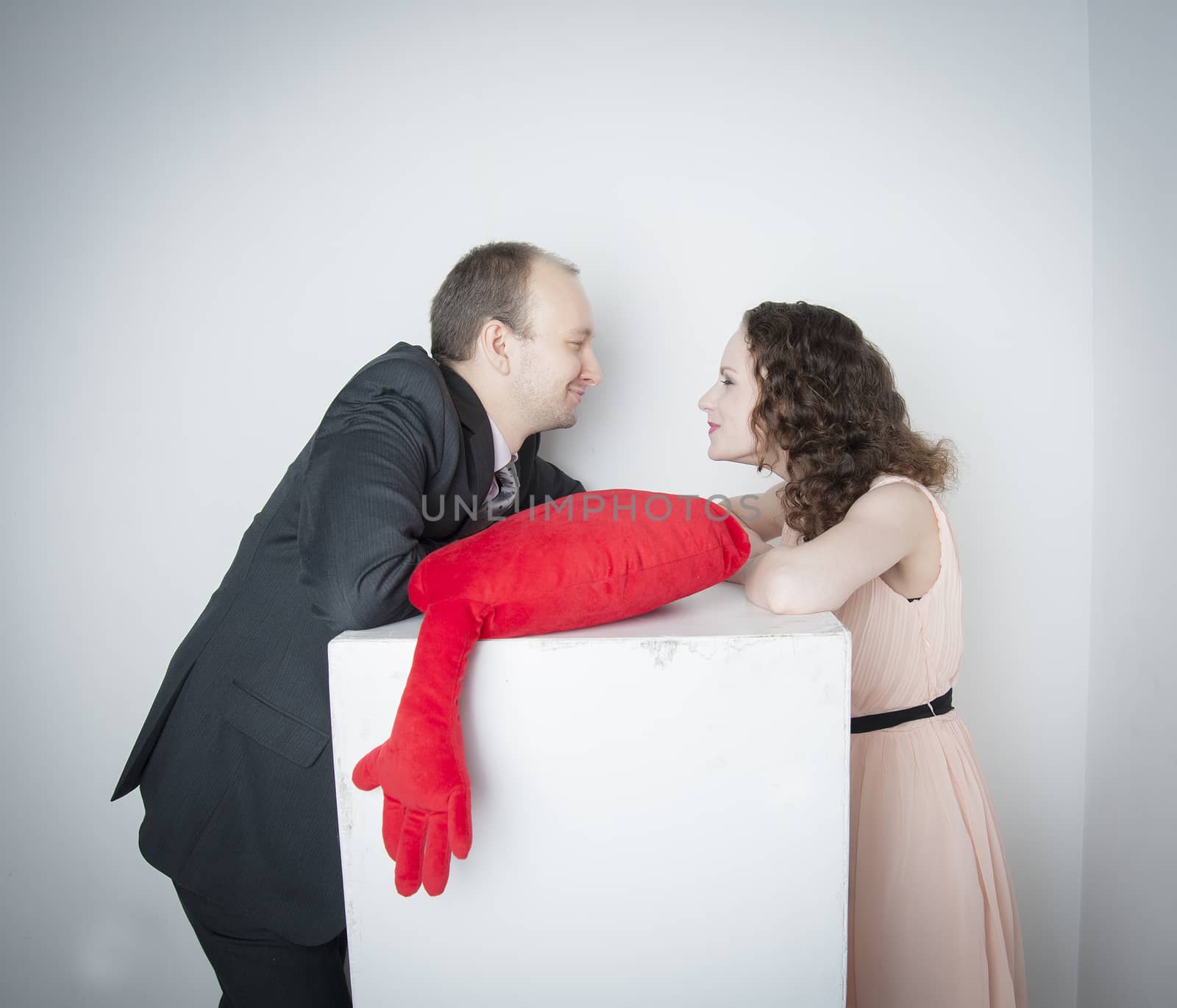 man and woman holding a red heart