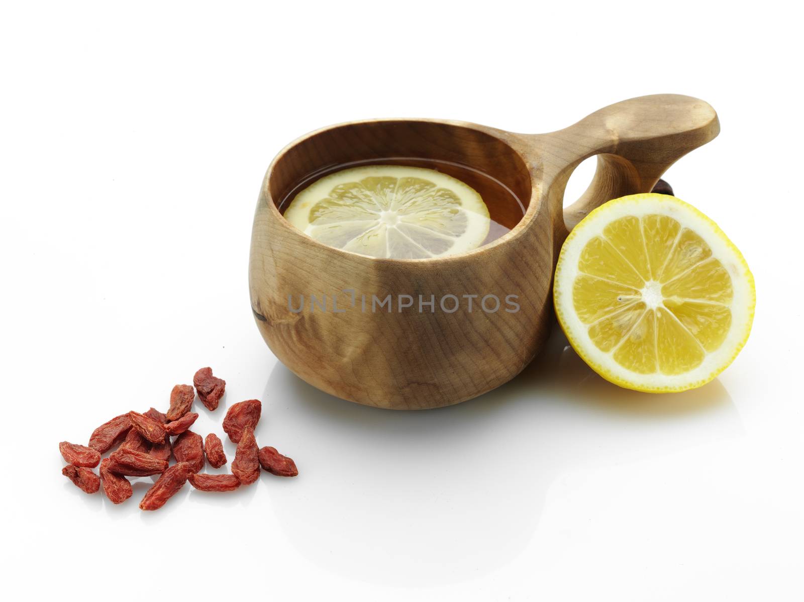 red dried goji berries on tea with lemon