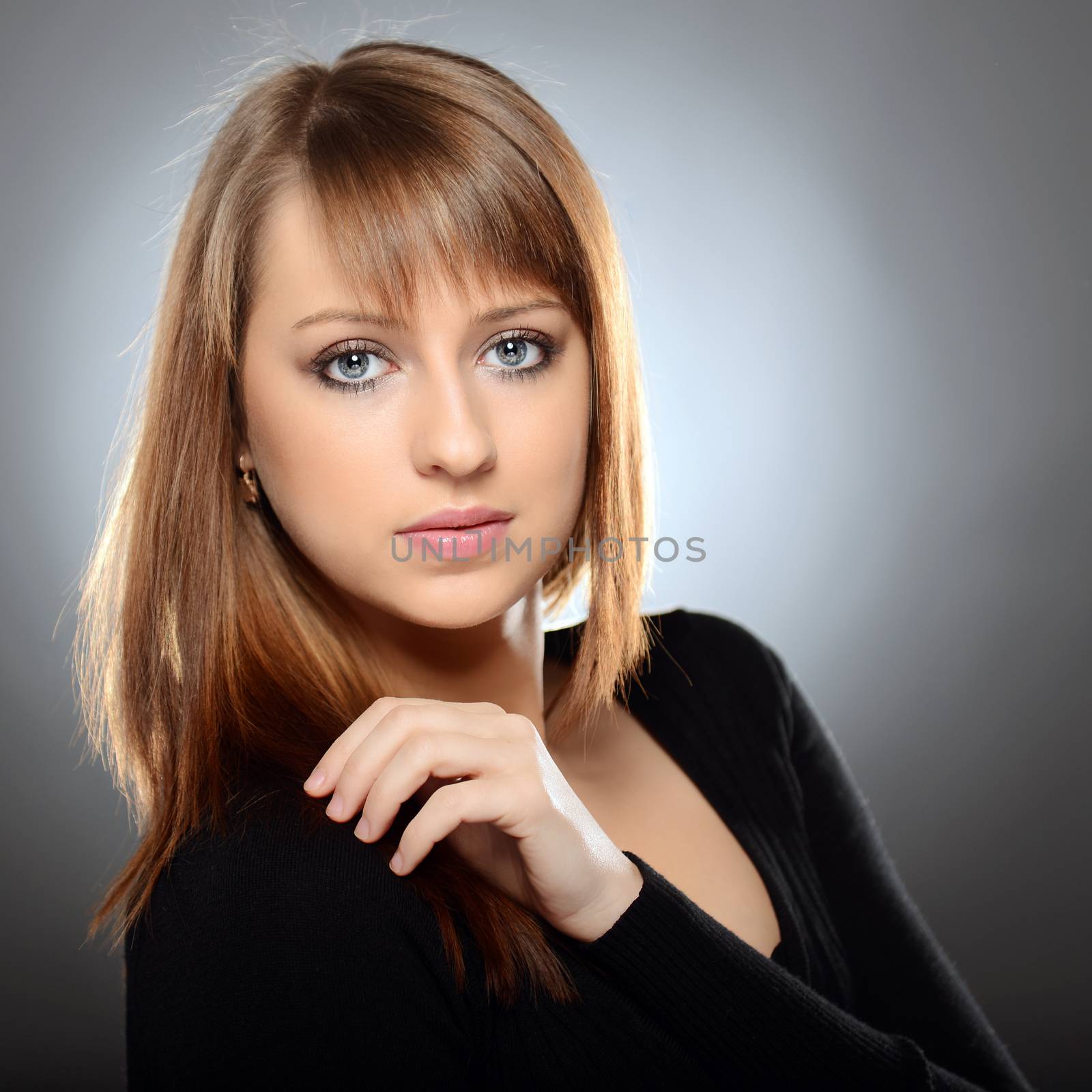 Beautiful brown haired woman posing over grey background