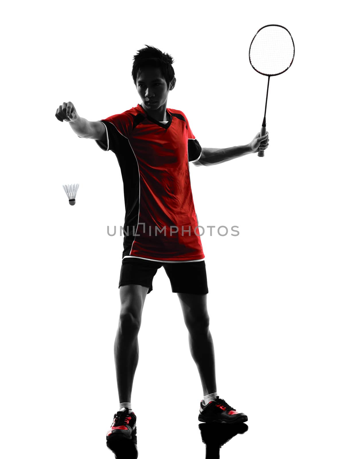 one asian badminton player young man at service in silhouette isolated white background
