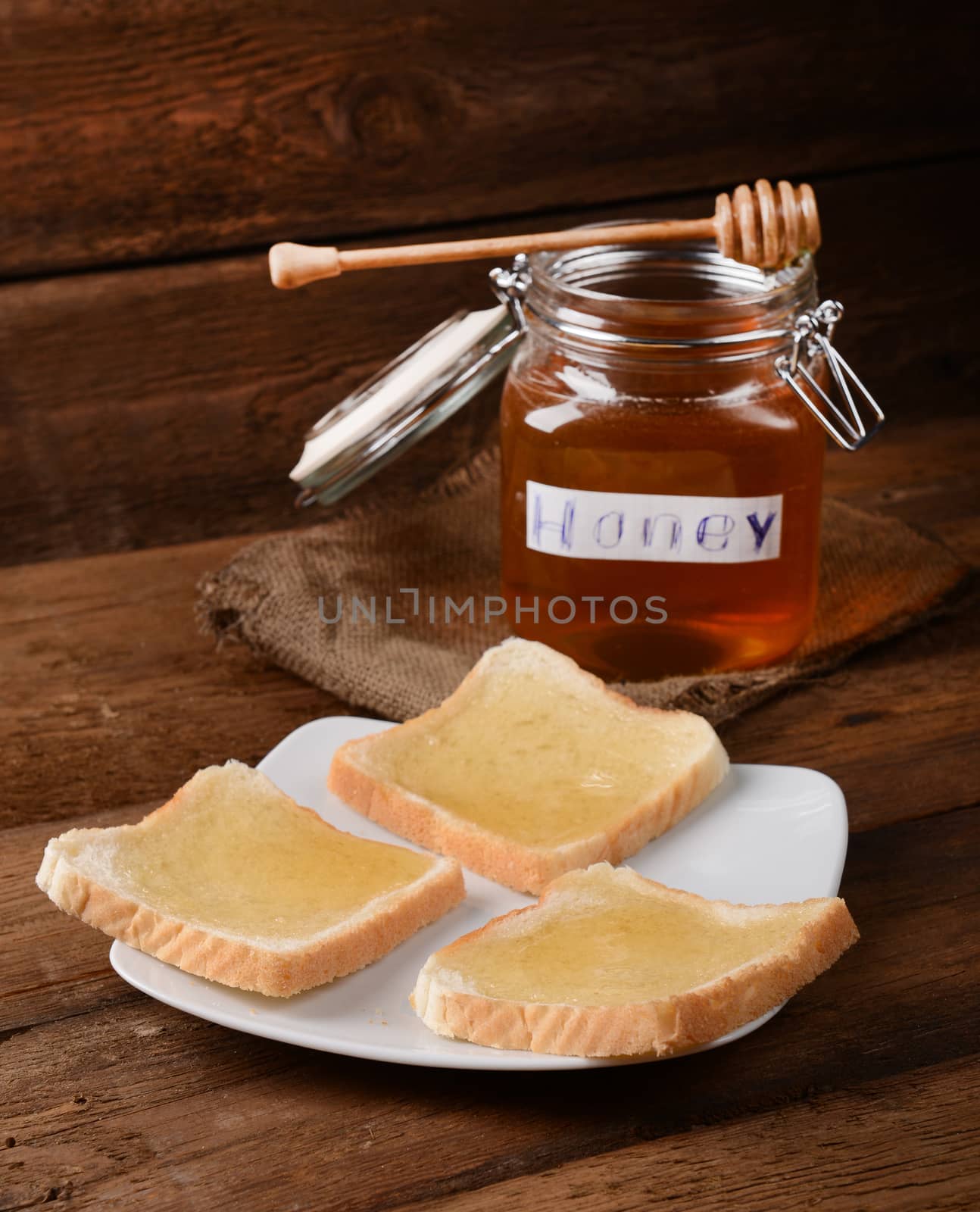 Fresh honey in glass jar on wooden background