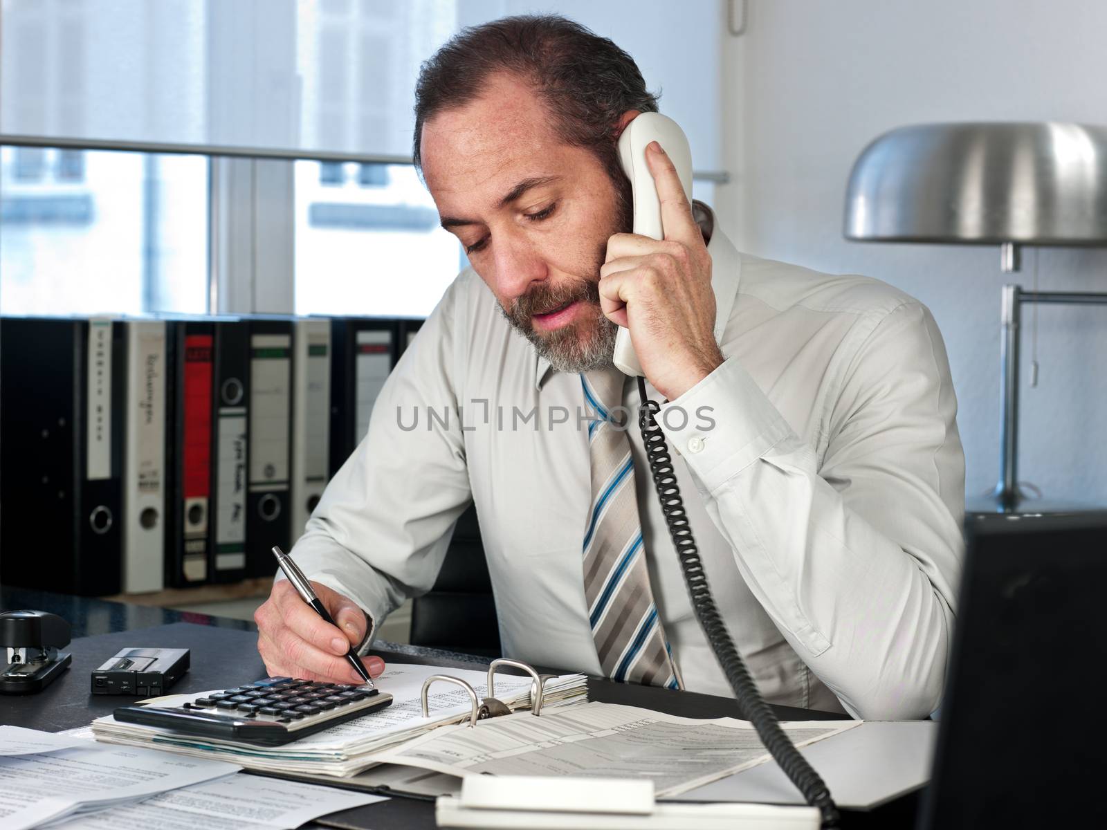 Mature businessman calculating finance. Horizontal shot