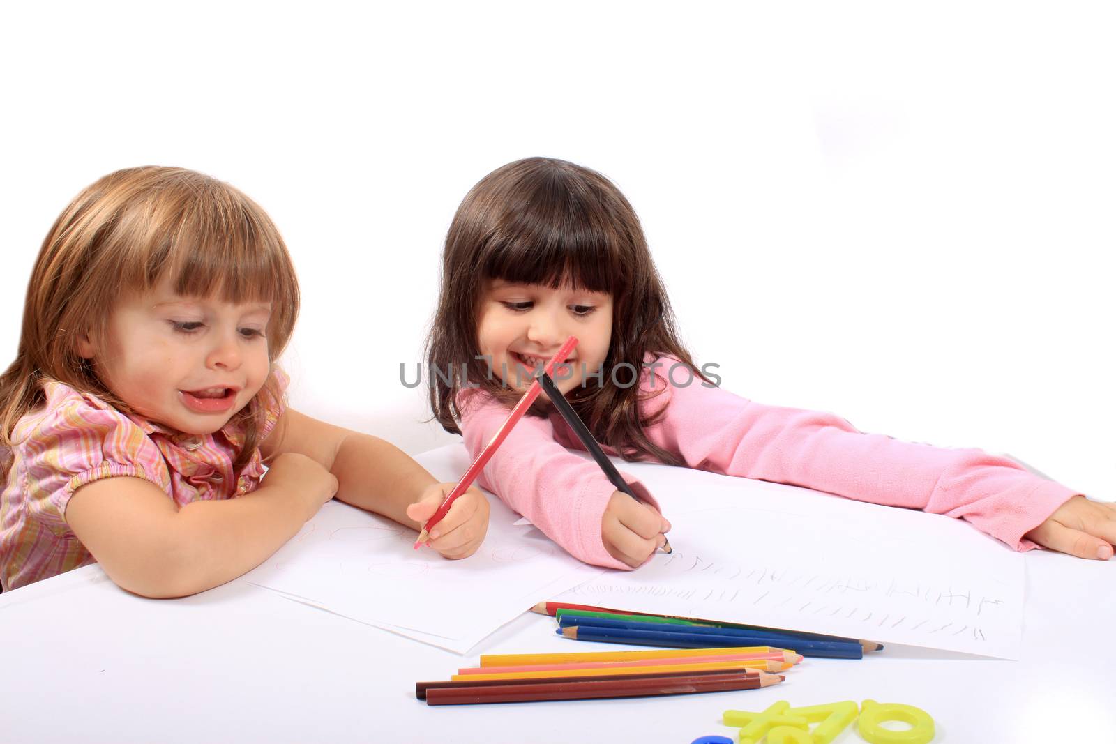 Two little preschool girls drawing with colorful pencil crayons