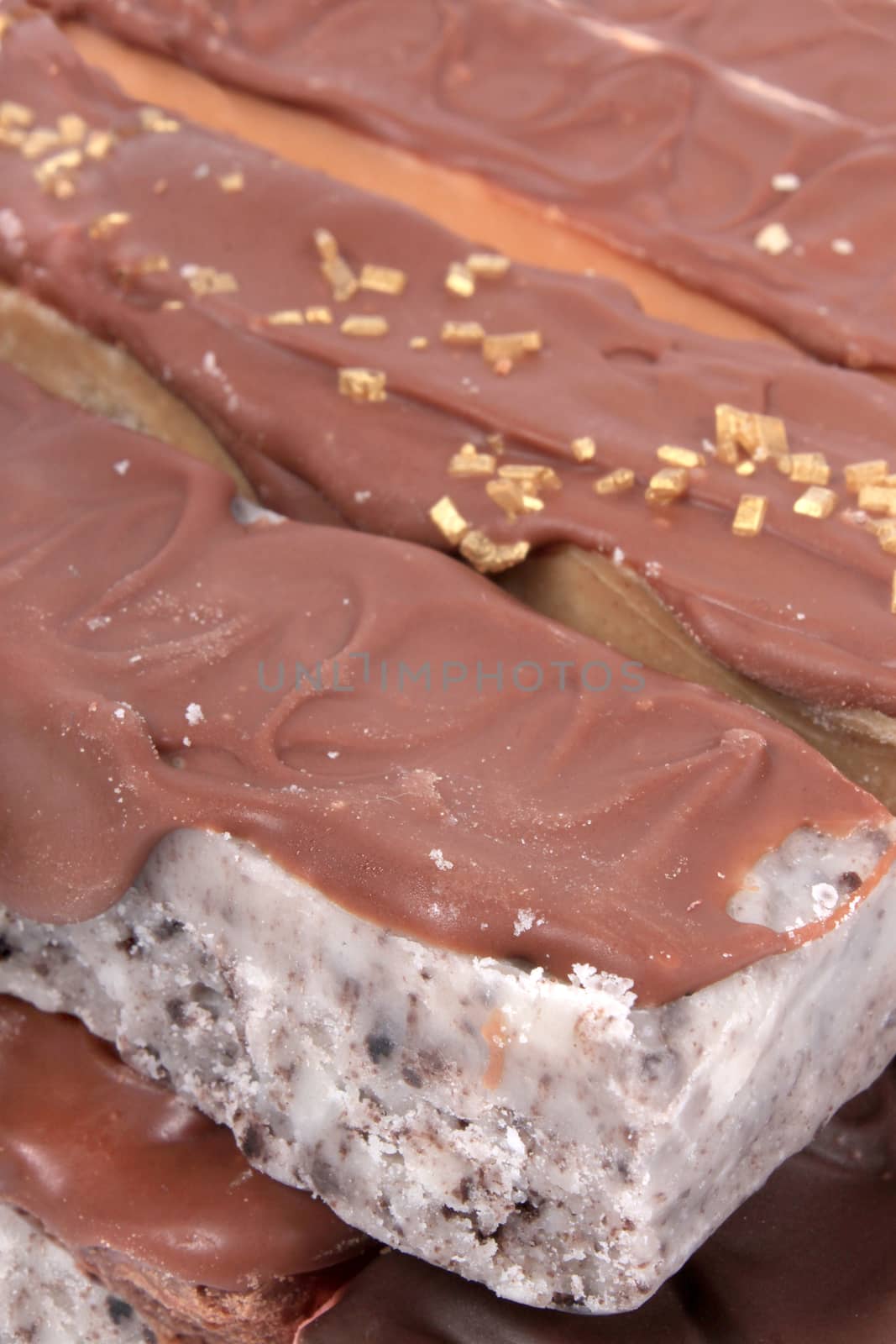 Close up of fudge bar pile in different colors and flavors covered in chocolate