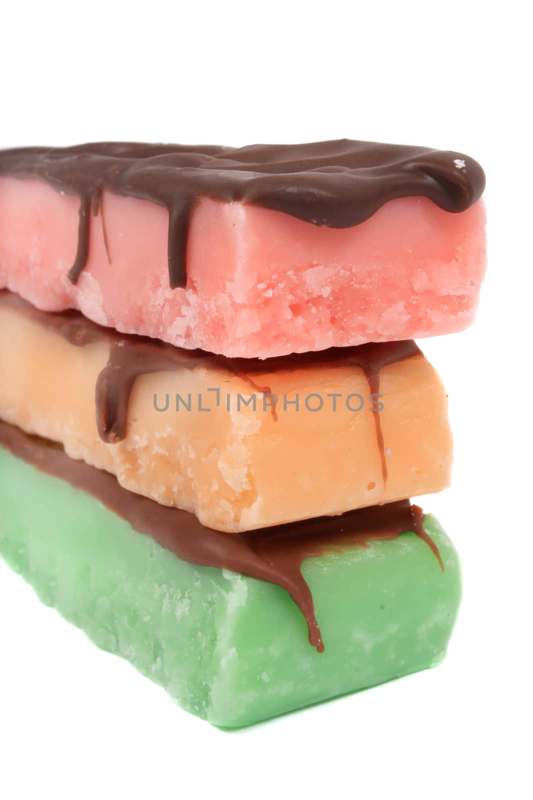 Three fudge bars in three color and flavors like mint, orange and strawberry on a white background