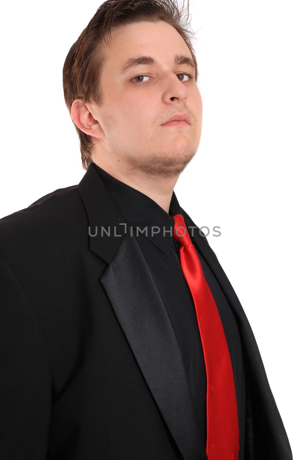 Handsome, cocky young businessman in black formal suit with red tie