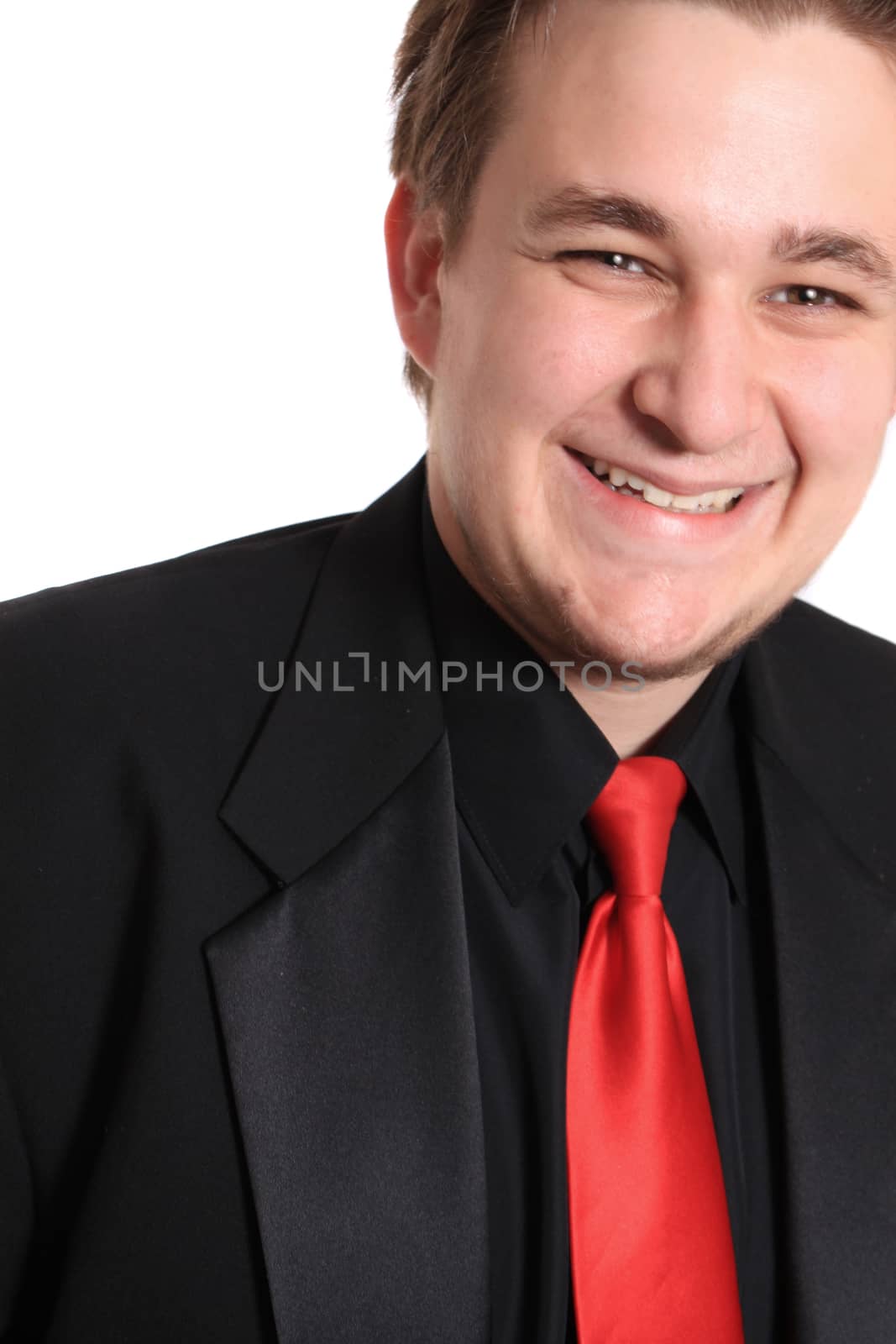 Handsome young businessman in black formal suit with red tie, smiling