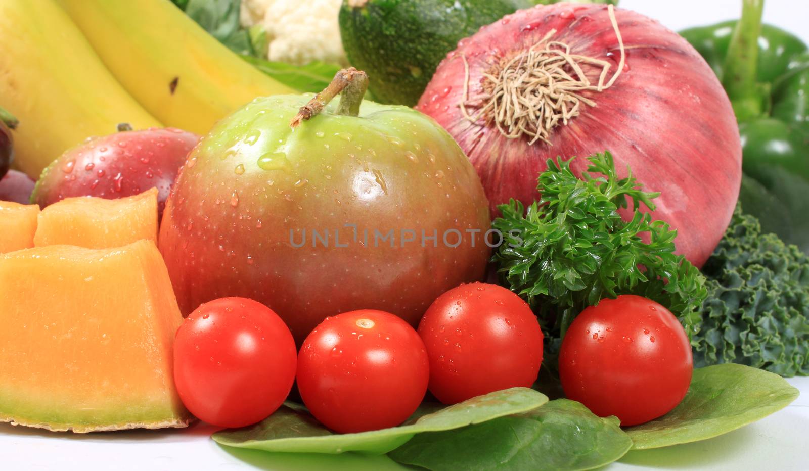 Group of wet with dew drops fruits and vegetables like grapes tomatoes, apple, red onion 