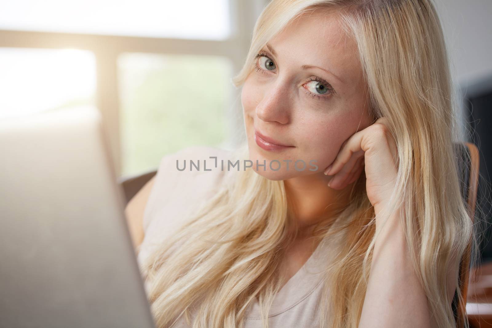 Pretty blond woman sitting with laptop