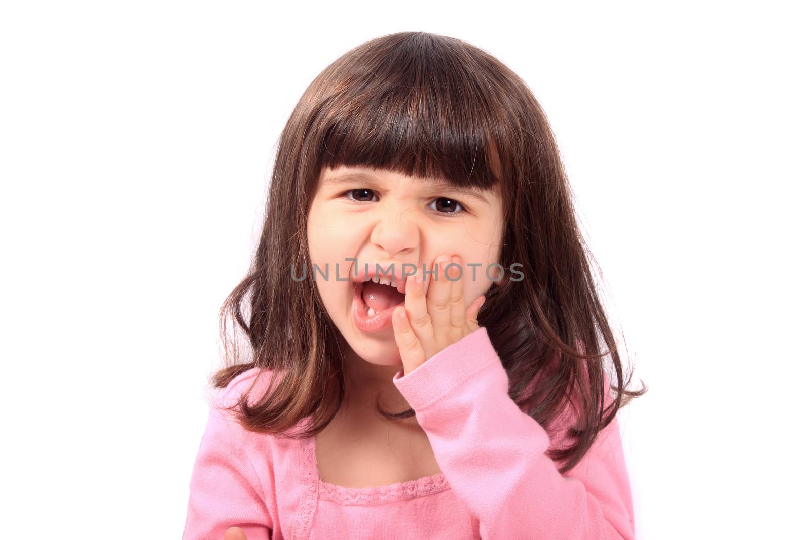 Cute young four year old child holding her cheek with a toothache