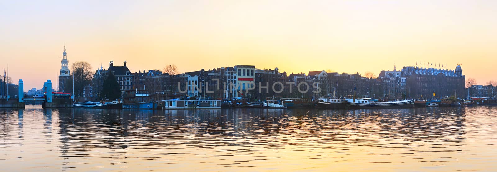 Panorama of Amsterdam old town with reflection in Amstel river