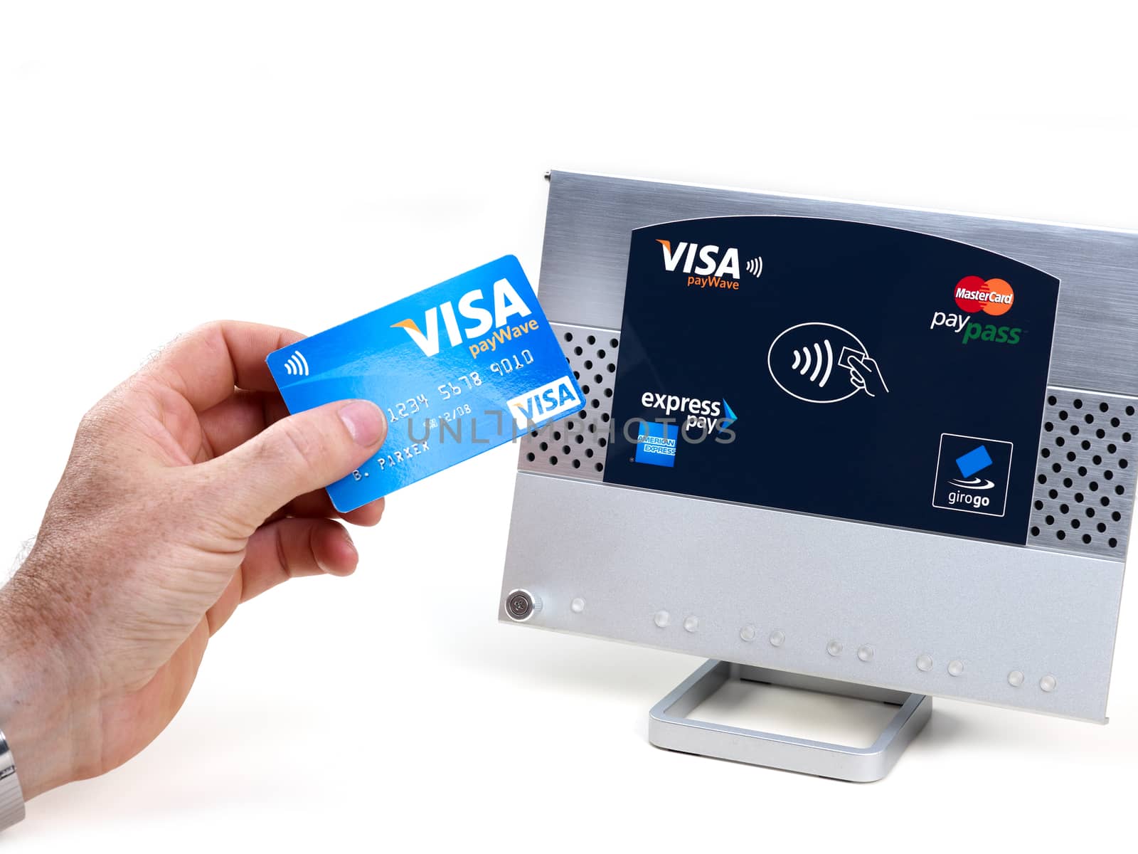 Aachen, Germany - August 05, 2012: Studioshot of payment action with the visa paywave credit card in front of a NFC terminal wich accepts visa, mastercard, american express and girogo contactless payments.