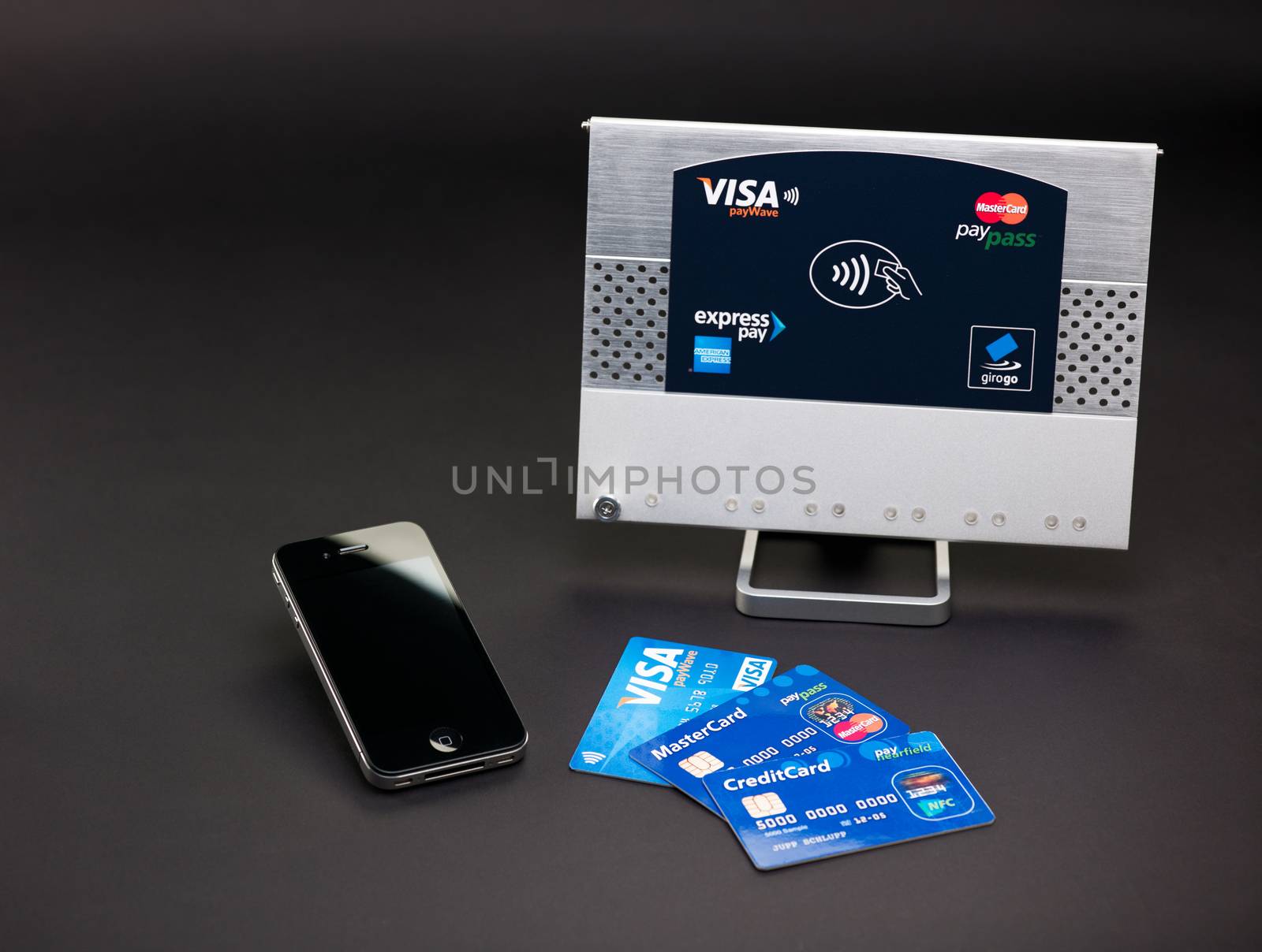 Aachen, Germany - August 05, 2012 - Studioshot of payment variations ( Apple iPhone 4, Visa paywve, mastercard paypass) in front of a NFC terminal wich accepts visa, mastercard, american express and girogo contactless payments.
