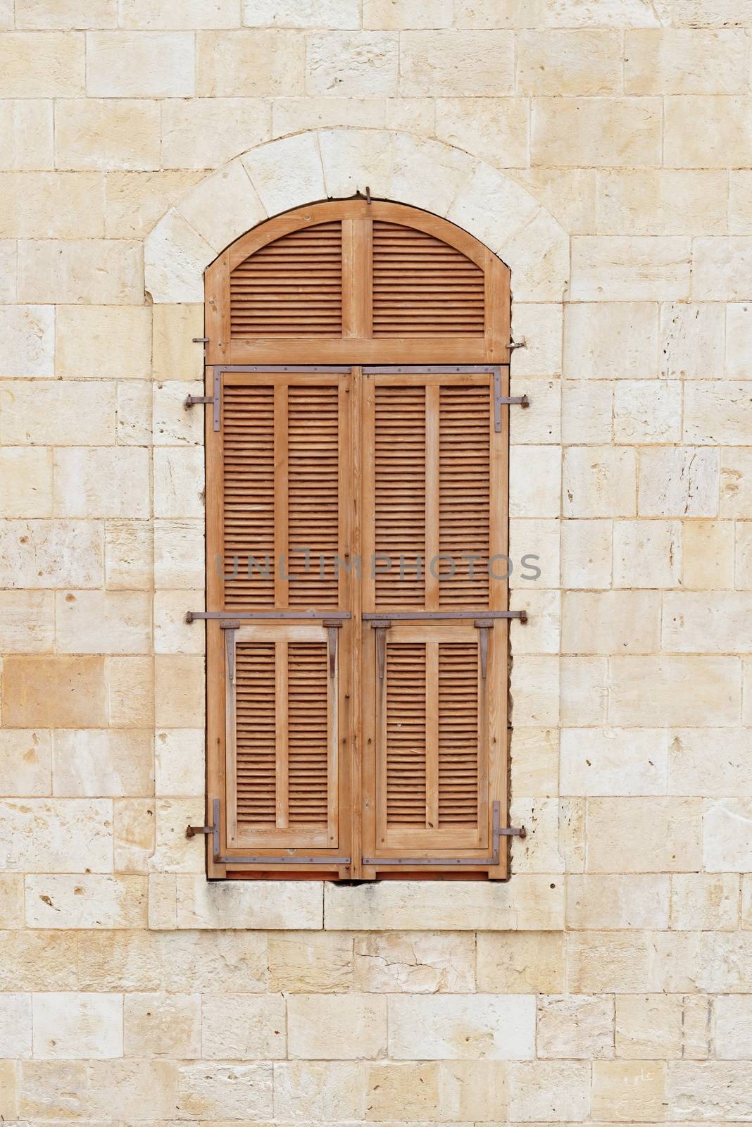 Closed window of the old building covered by wooden blinds