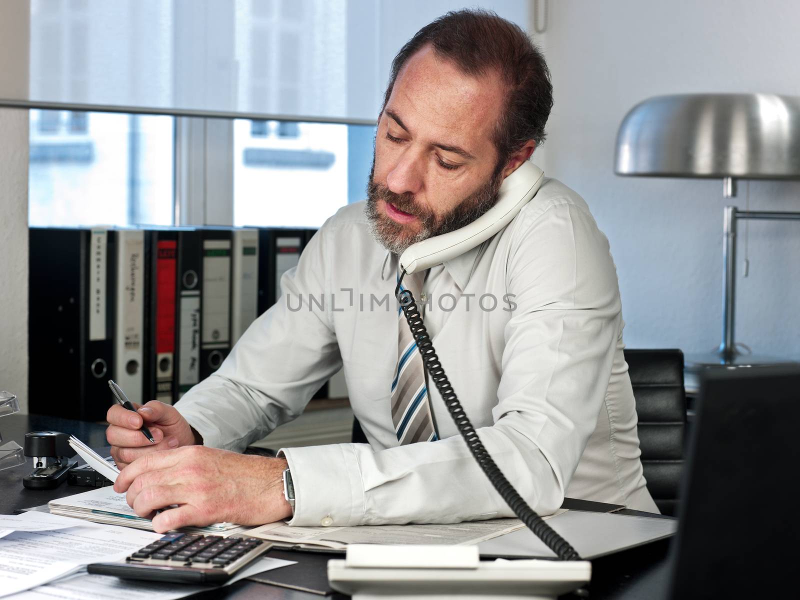 Mature businessman calculating finance. Horizontal shot