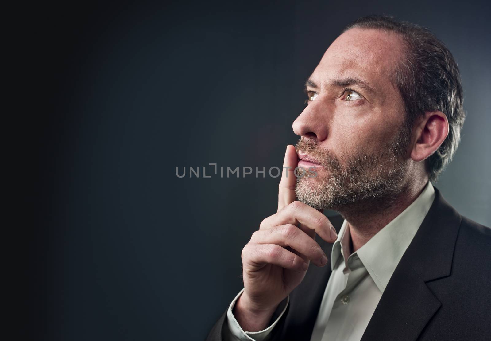 Studio shot of businessman in a deep thought over colored background (shot on PhaseOne 45)
