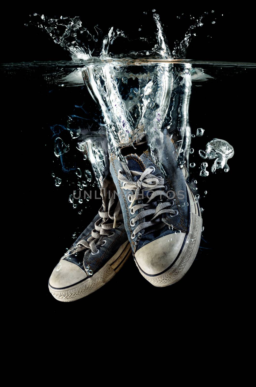 Splashing  old dirty sneakers on a black  background