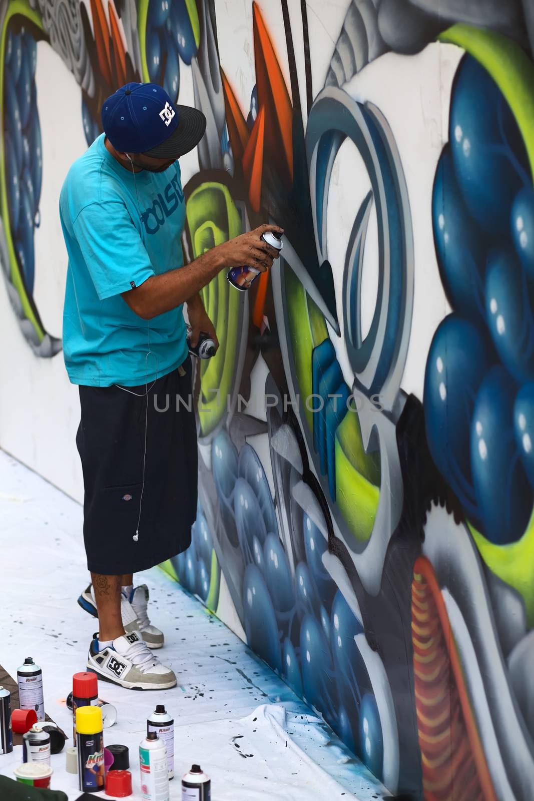 LIMA, PERU - MARCH 3, 2012: Unidentified young man spraying a wall on the Latir Latino, the first Latin-American Street Art Festival on March 3, 2012 in Miraflores, Lima, Peru. Many national and international street artists participated on this Festival, which was organised by the Municipality of Miraflores.