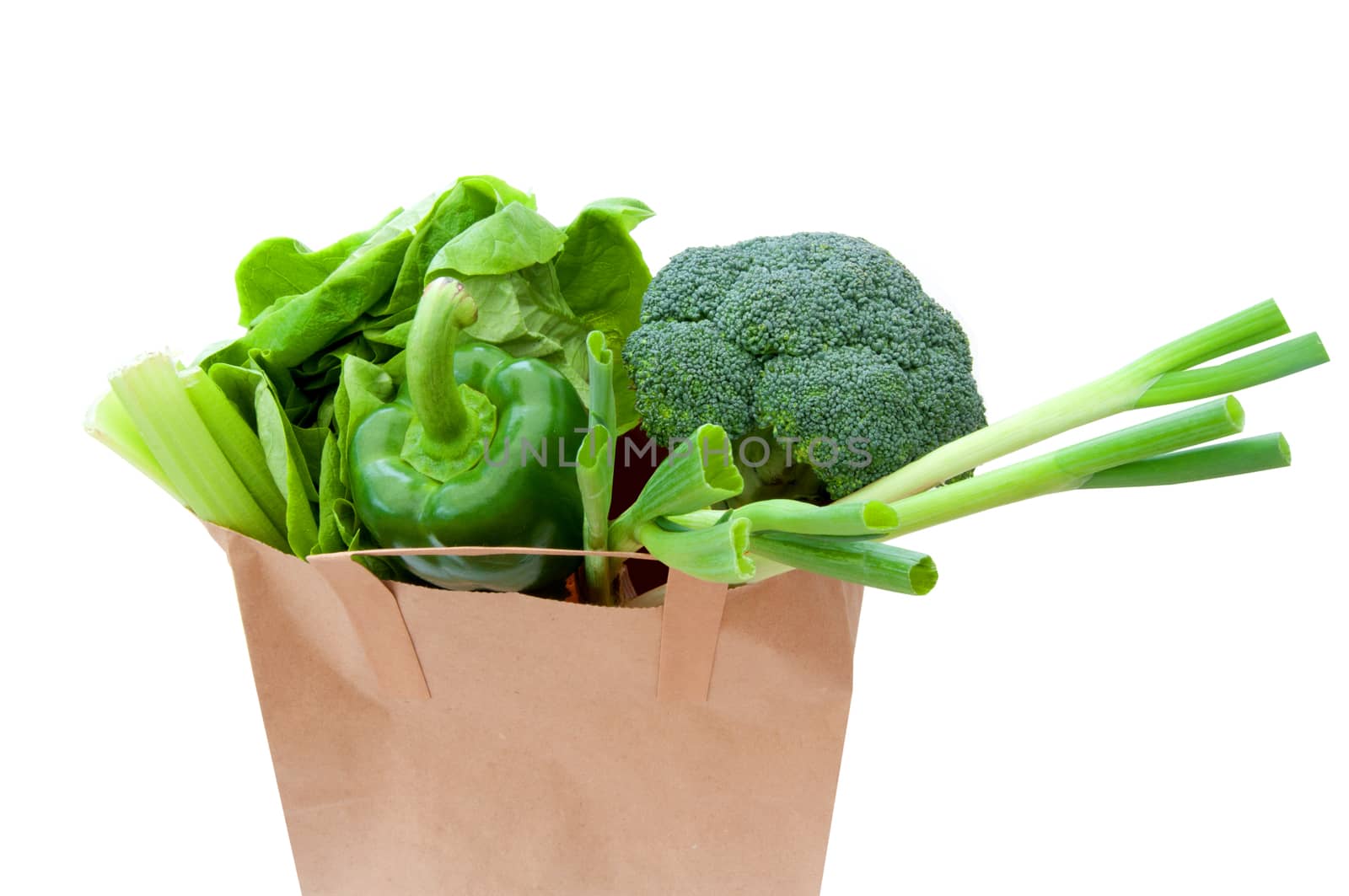 Brown paper bag with healthy green vegetables over a white background 