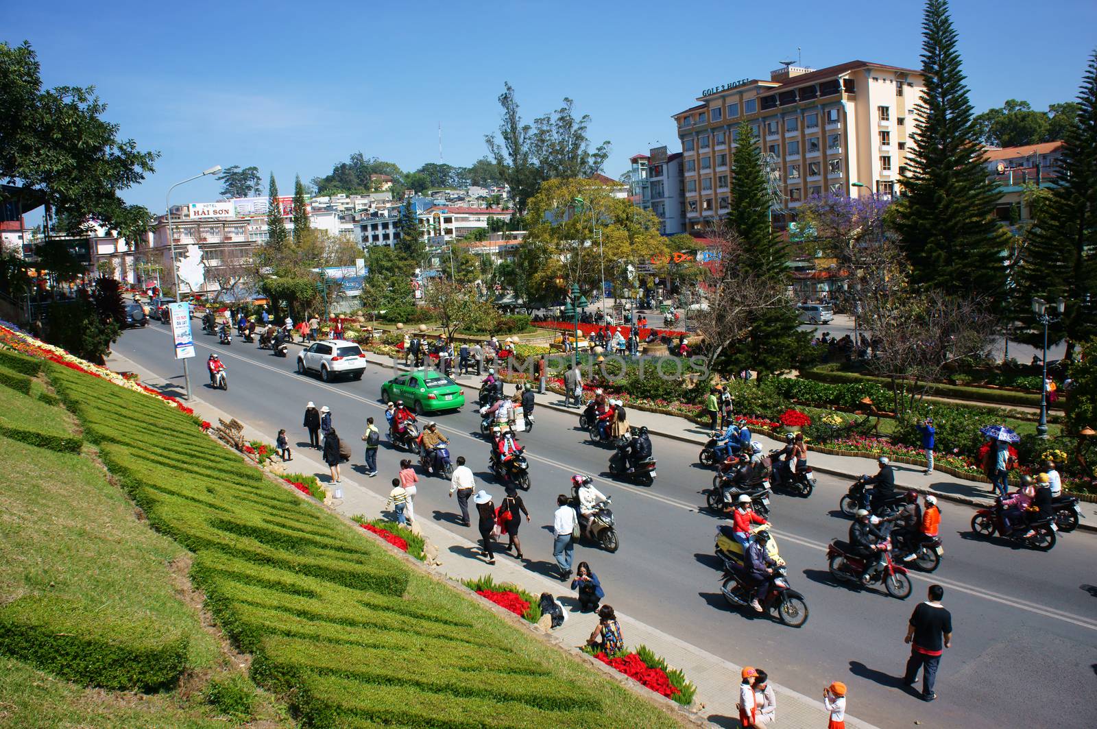 DA LAT, VIET NAM- DEC 28: Traveler travel on holiday (vacation) at flower city, group of people walking, enjoy springtime,  take photo with flower show on street in Dalat, Vietnam on Dec 28, 2013