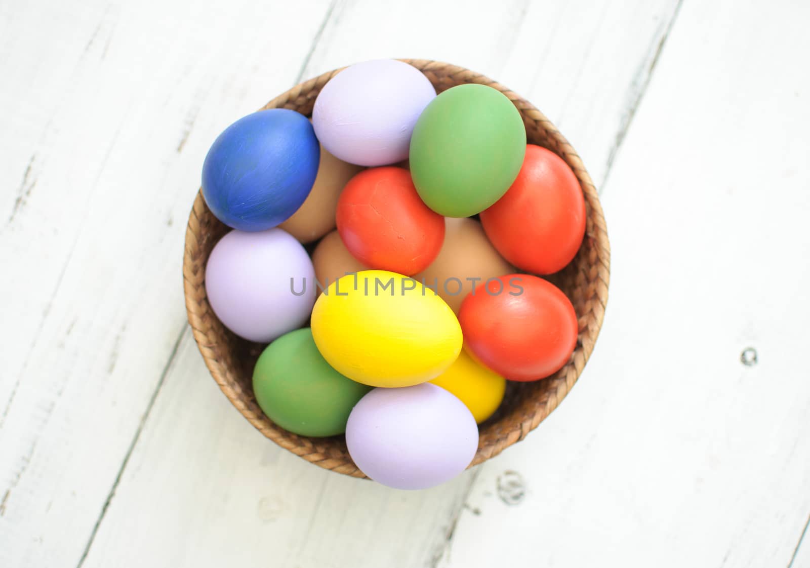 Colorful painted easter eggs inside a basket 