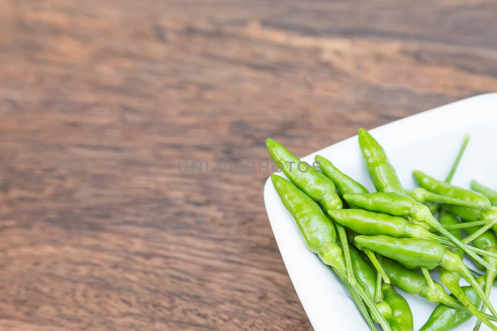 Green peppers in close up against wood background