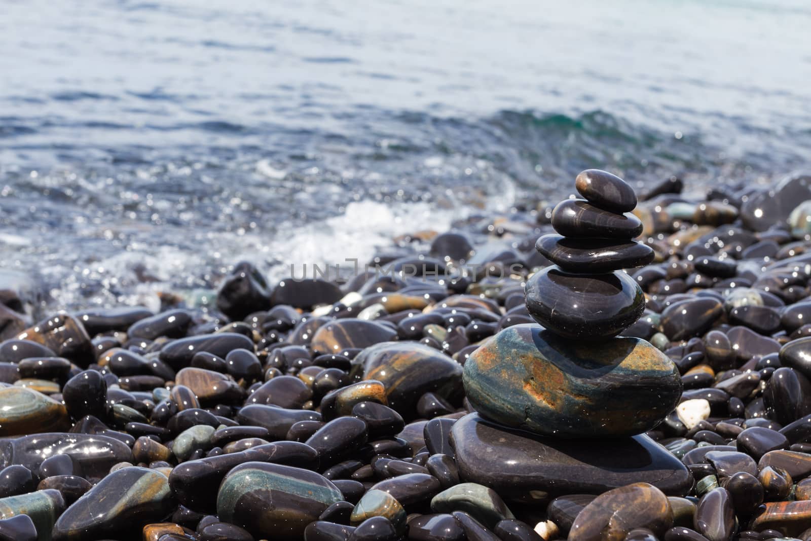 Stones pyramid on stone beach symbolizing zen