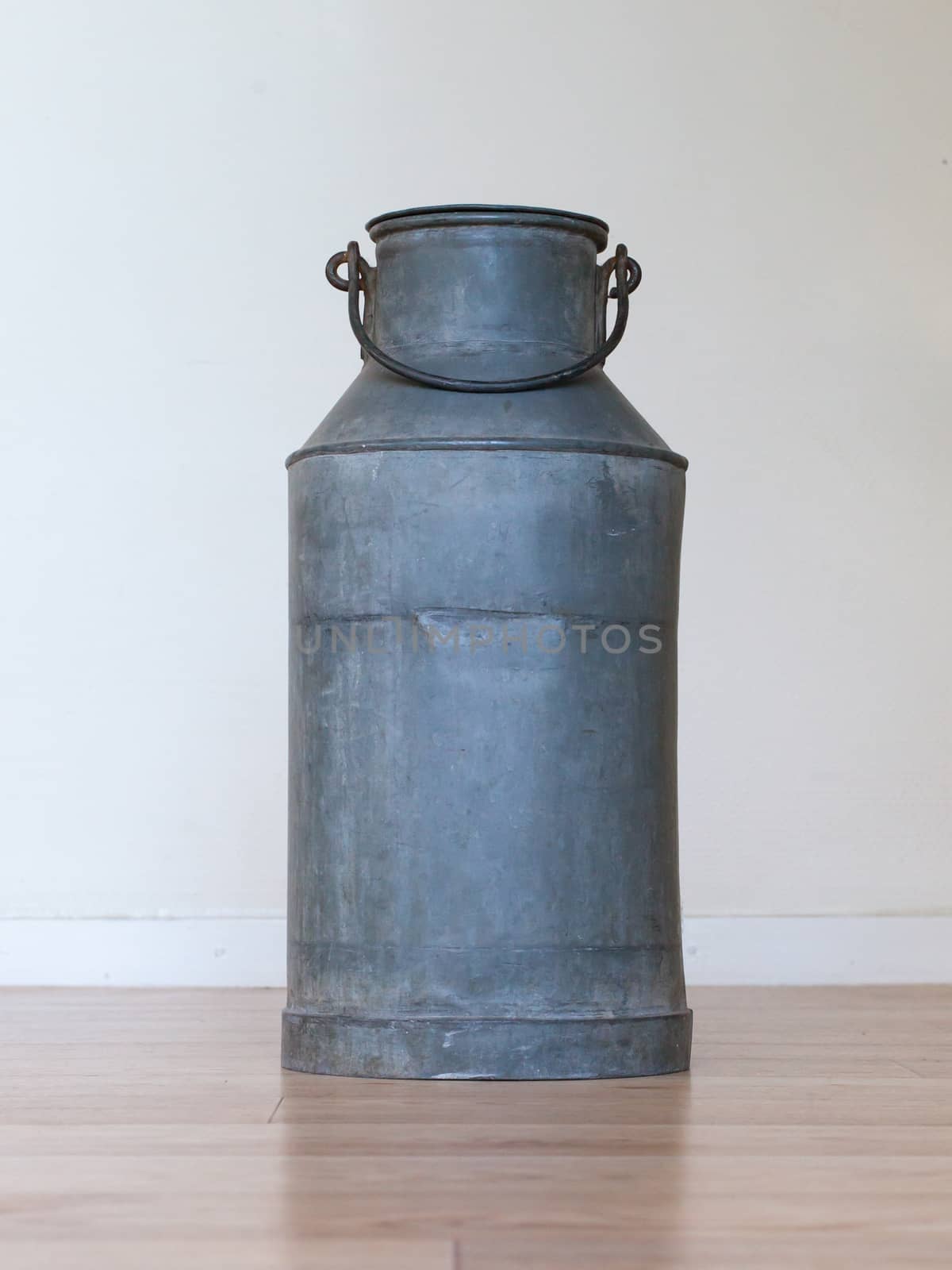 Old metal milk can on white background