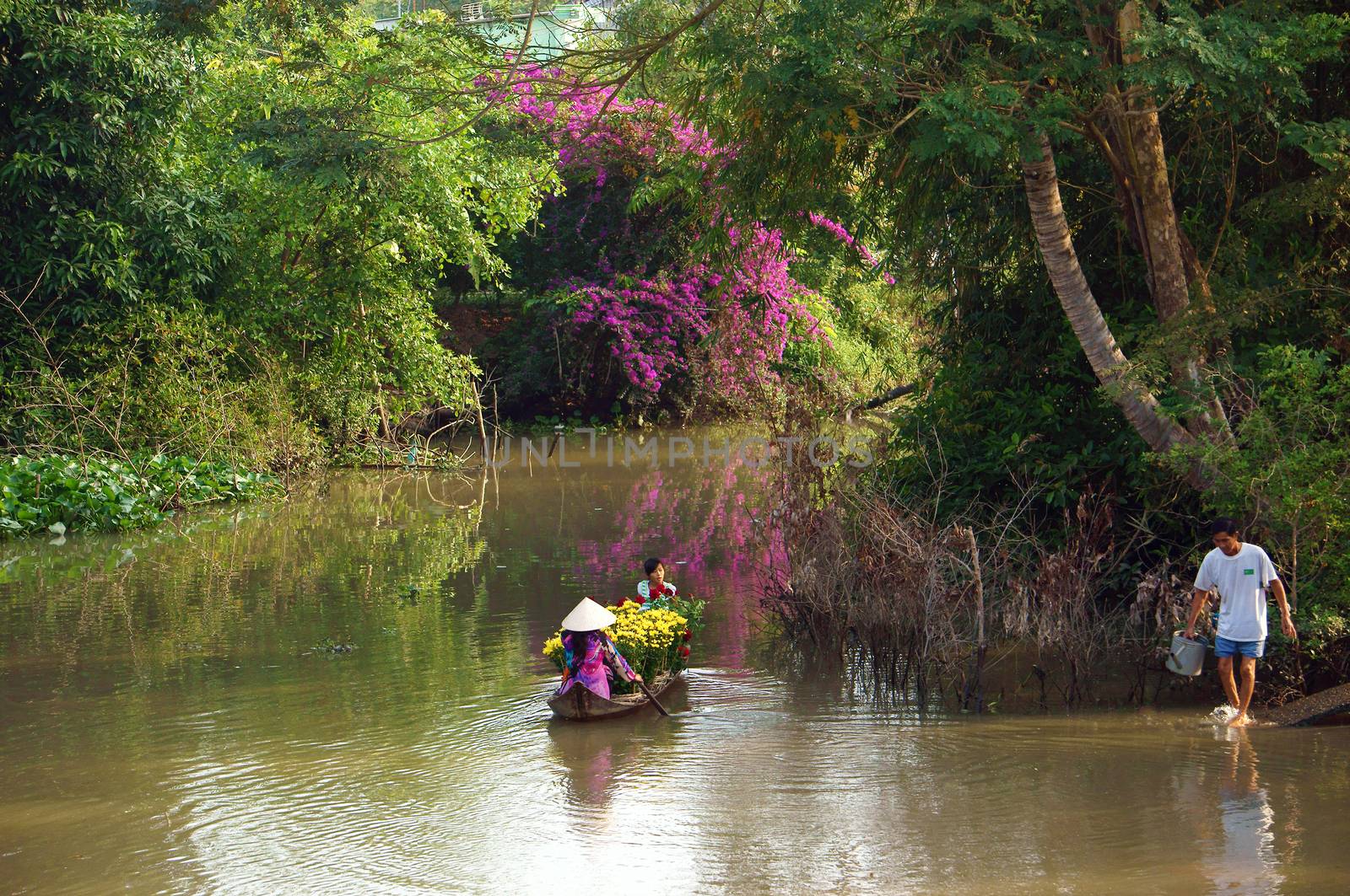 women and children on rowboat with flower forTet in springtime by xuanhuongho