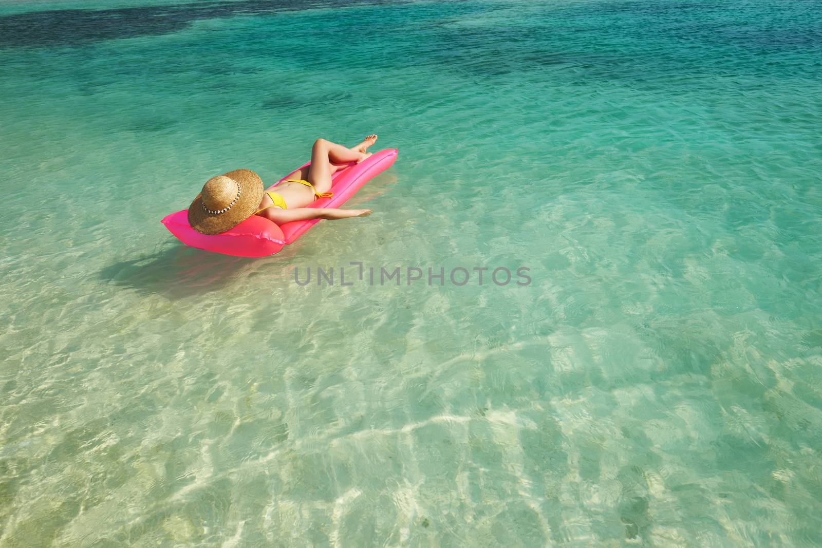 Woman relaxing on inflatable mattress at the beach