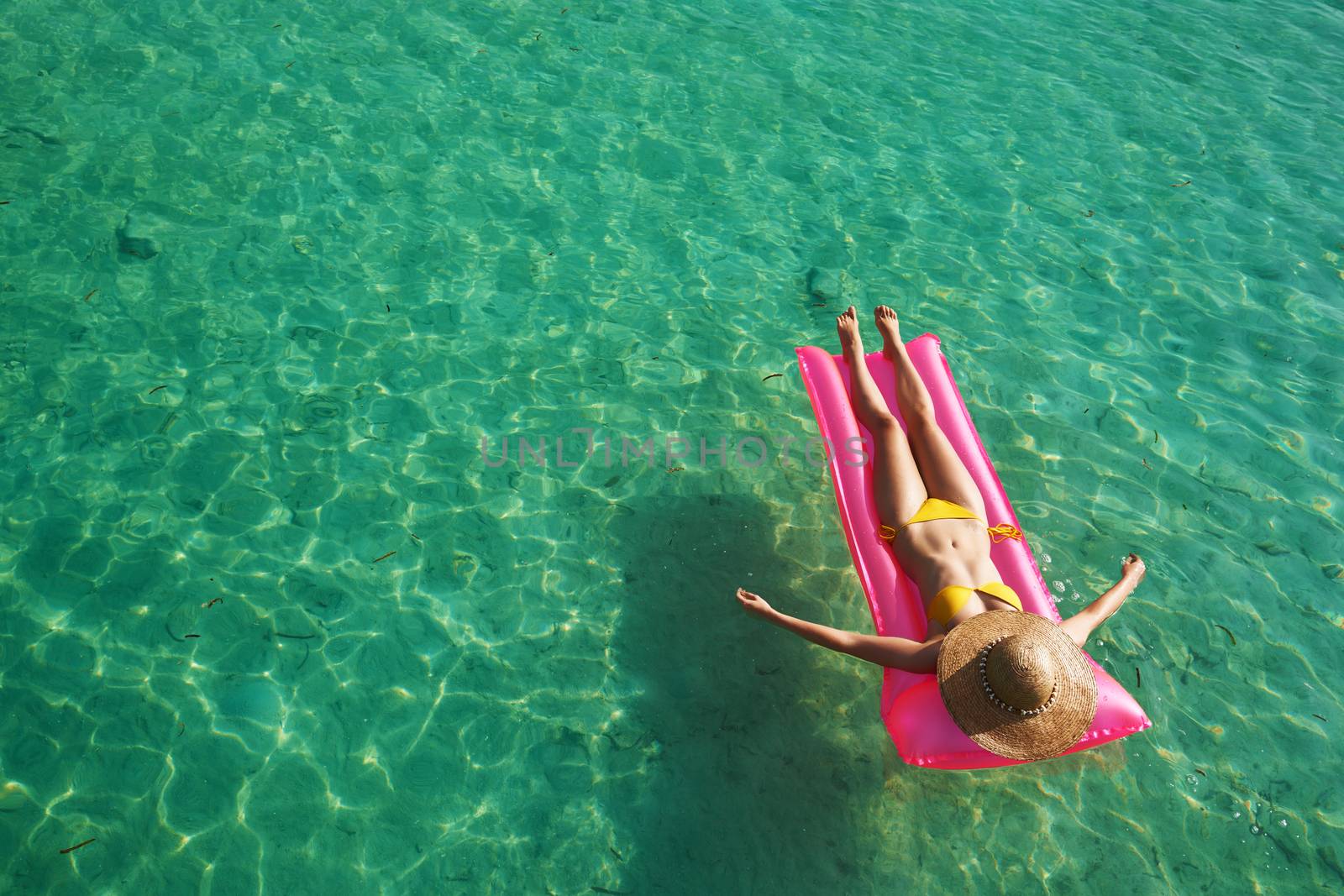 Woman relaxing on inflatable mattress at the beach