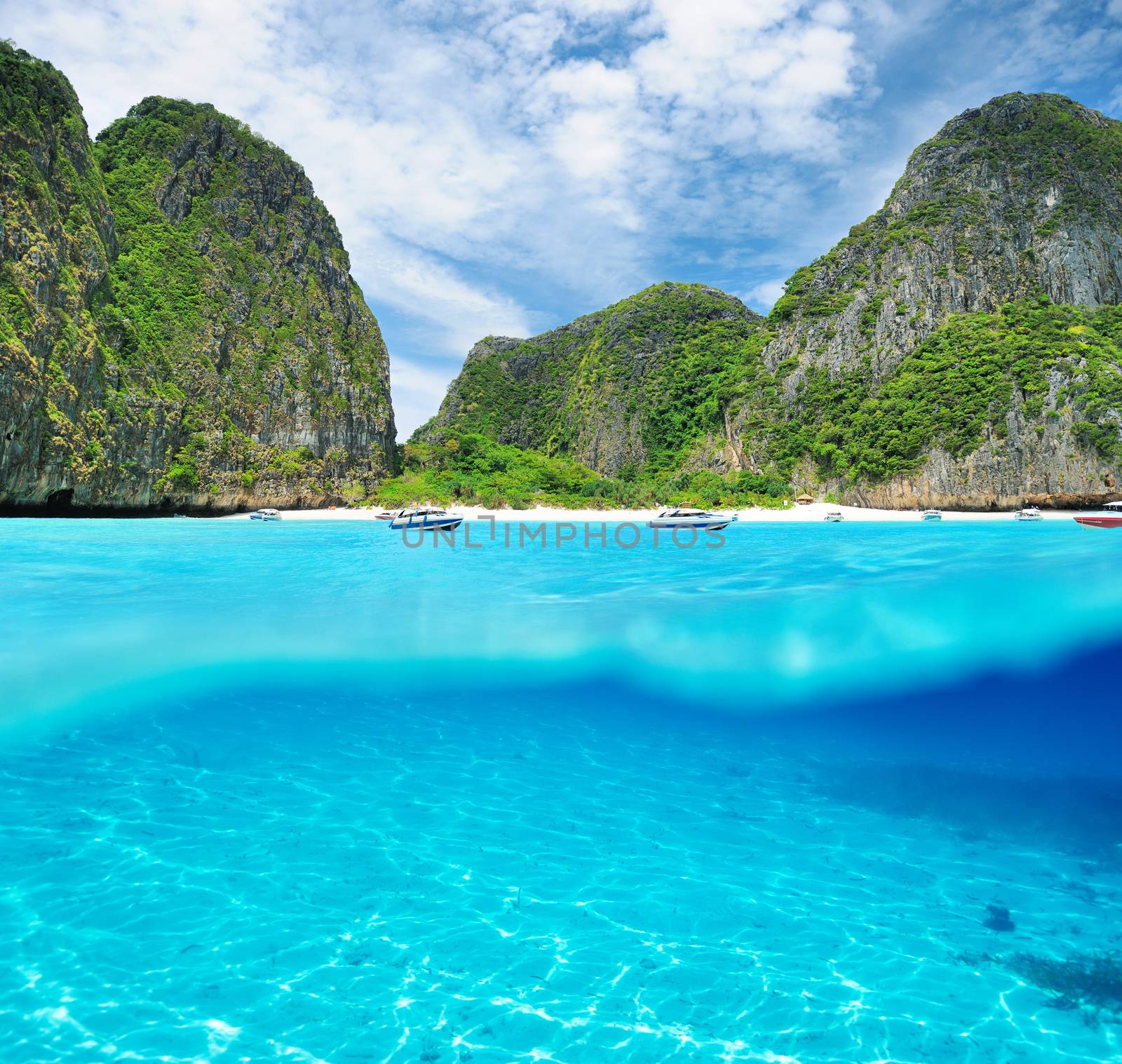 Beautiful lagoon at  Phi Phi Ley island with white sand bottom underwater and above water split view