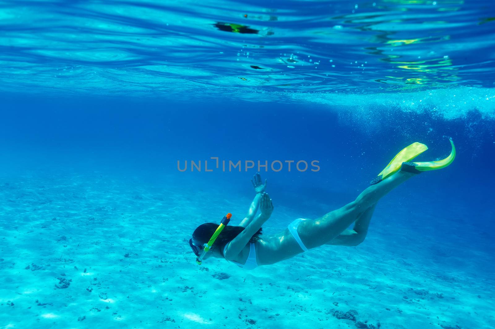 Woman with mask snorkeling in clear water 