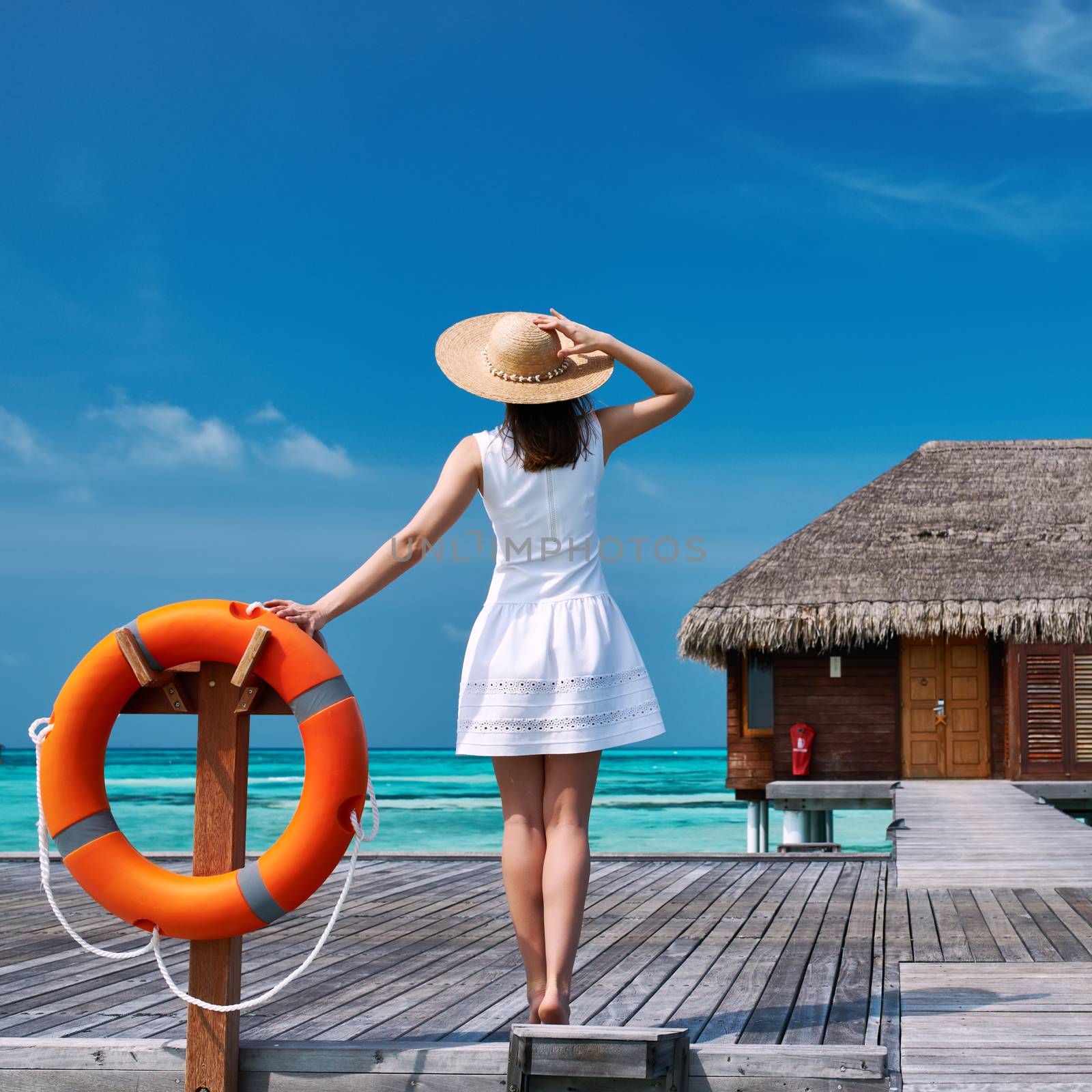 Woman on a tropical beach jetty at Maldives