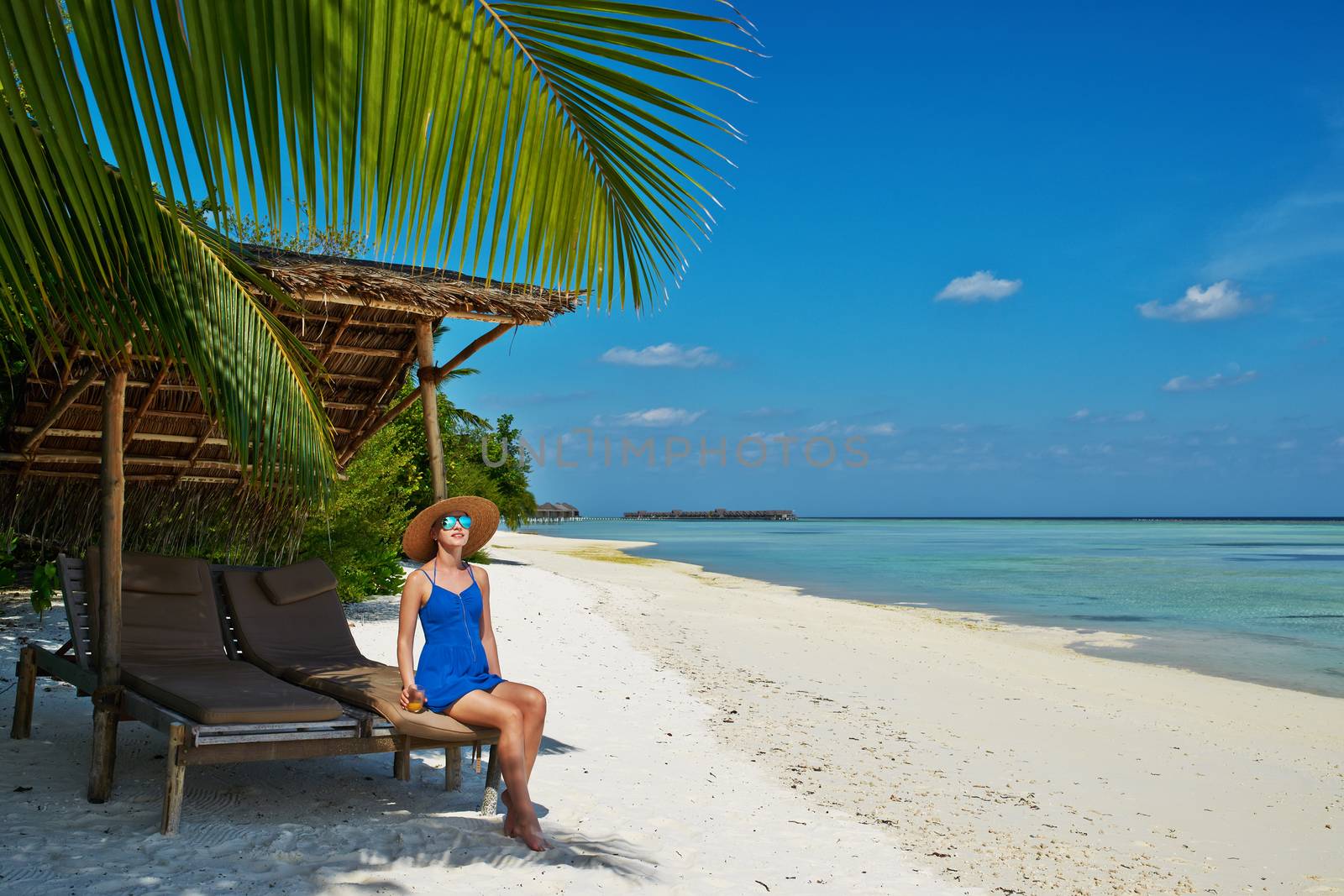 Woman in blue dress on a tropical beach at Maldives