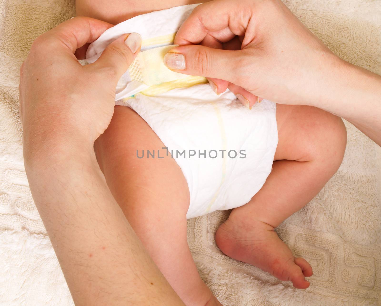 Diaper change on a newborn baby by female with manicure