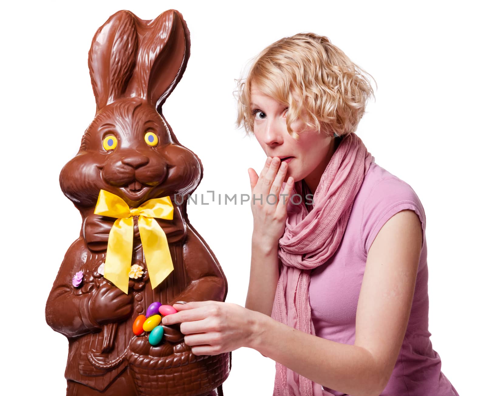 Blond Girl stealing Easter Eggs of a Chocolate Bunny Isolated on White Background