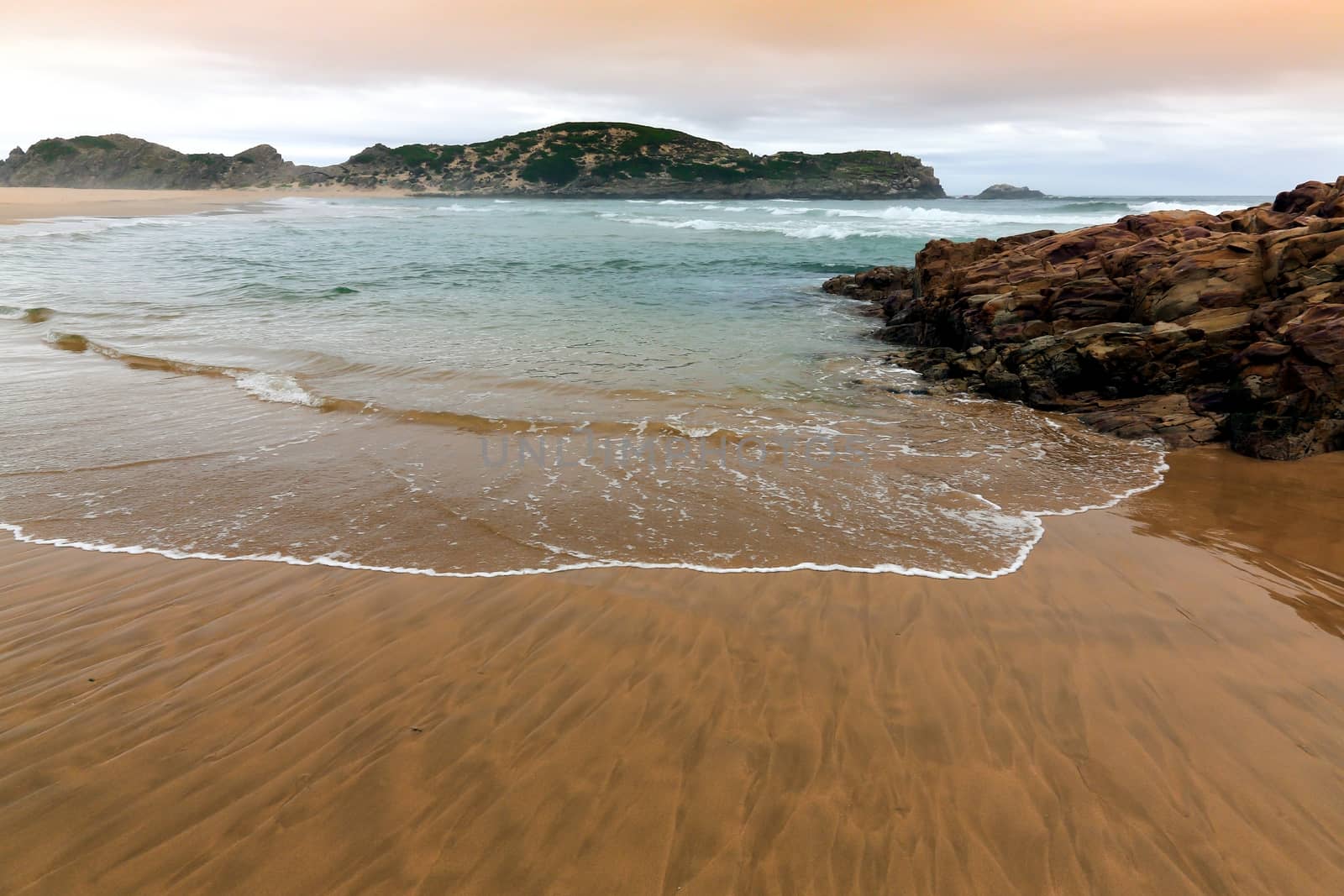 Rough sea and golden sand at the rugged coast in South Africa