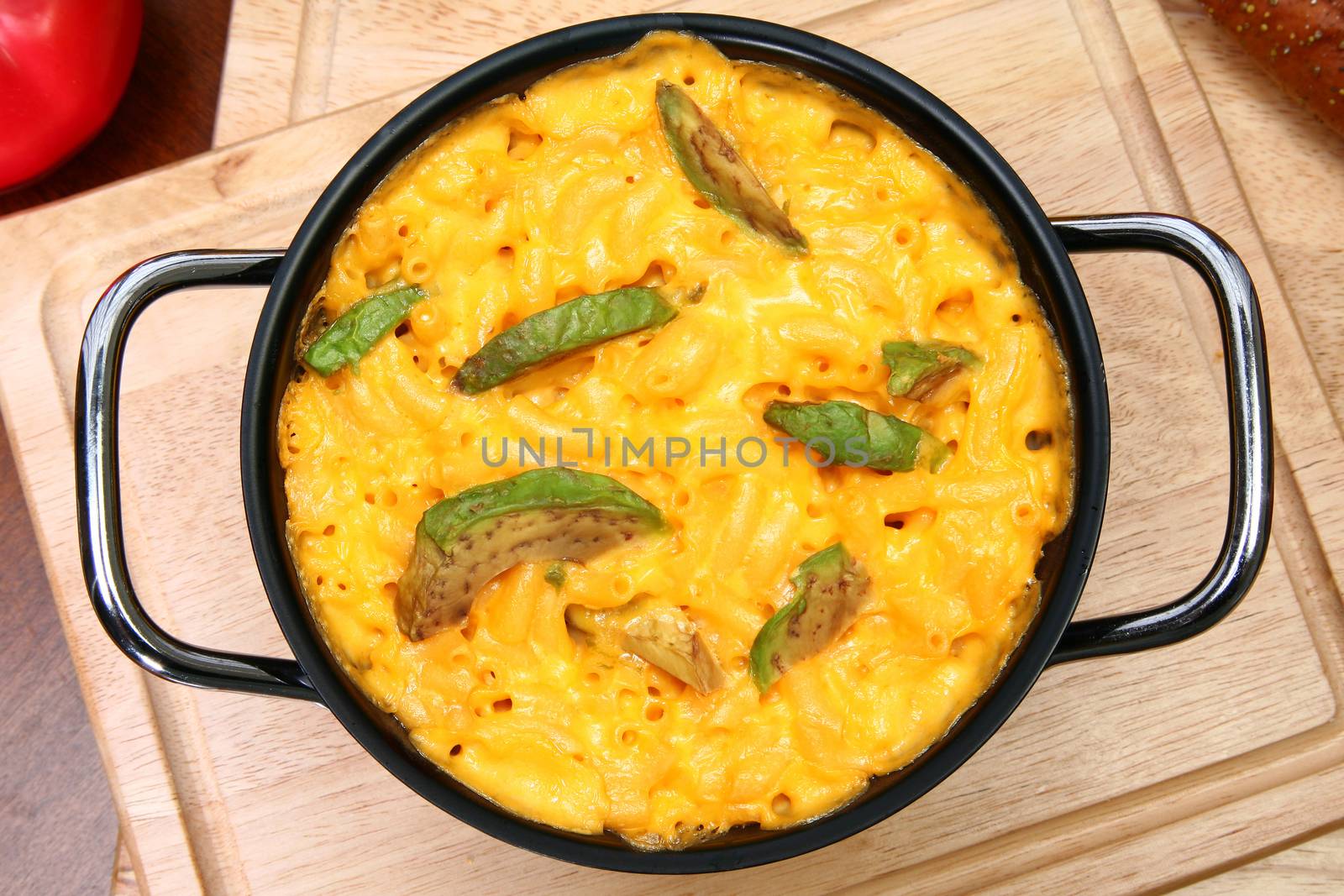 Pot of Macaroni and Cheese with Avocado Slices on Table by duplass