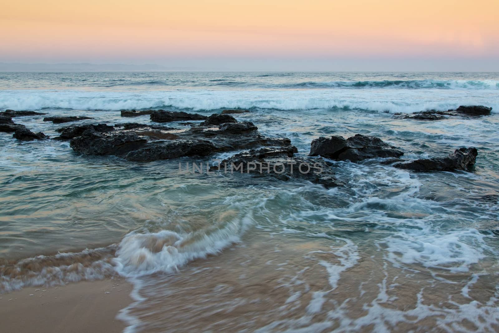 Rough sea and sunset at the rugged coast in South Africa