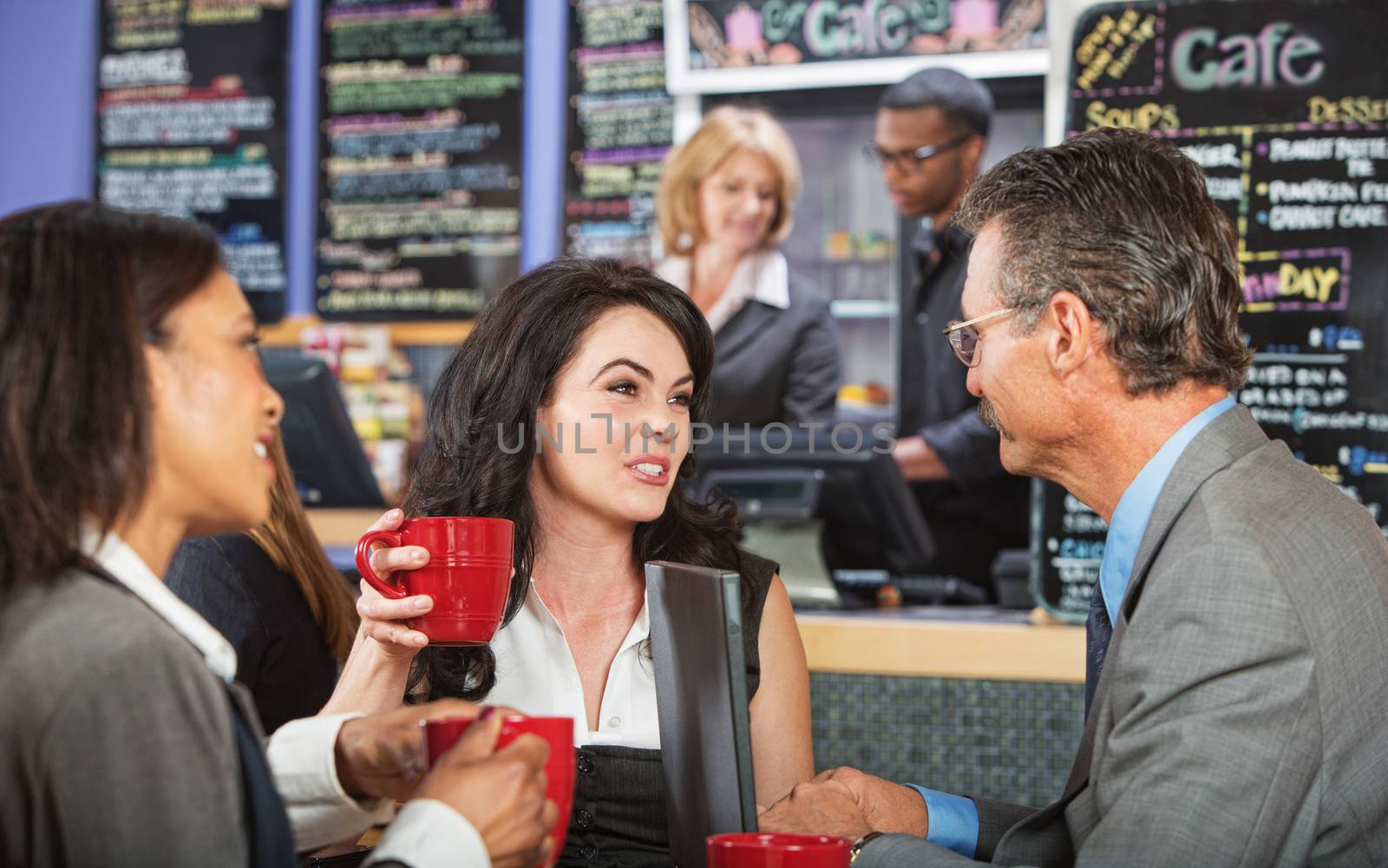 Mixed group of coworkers talking in a cafe
