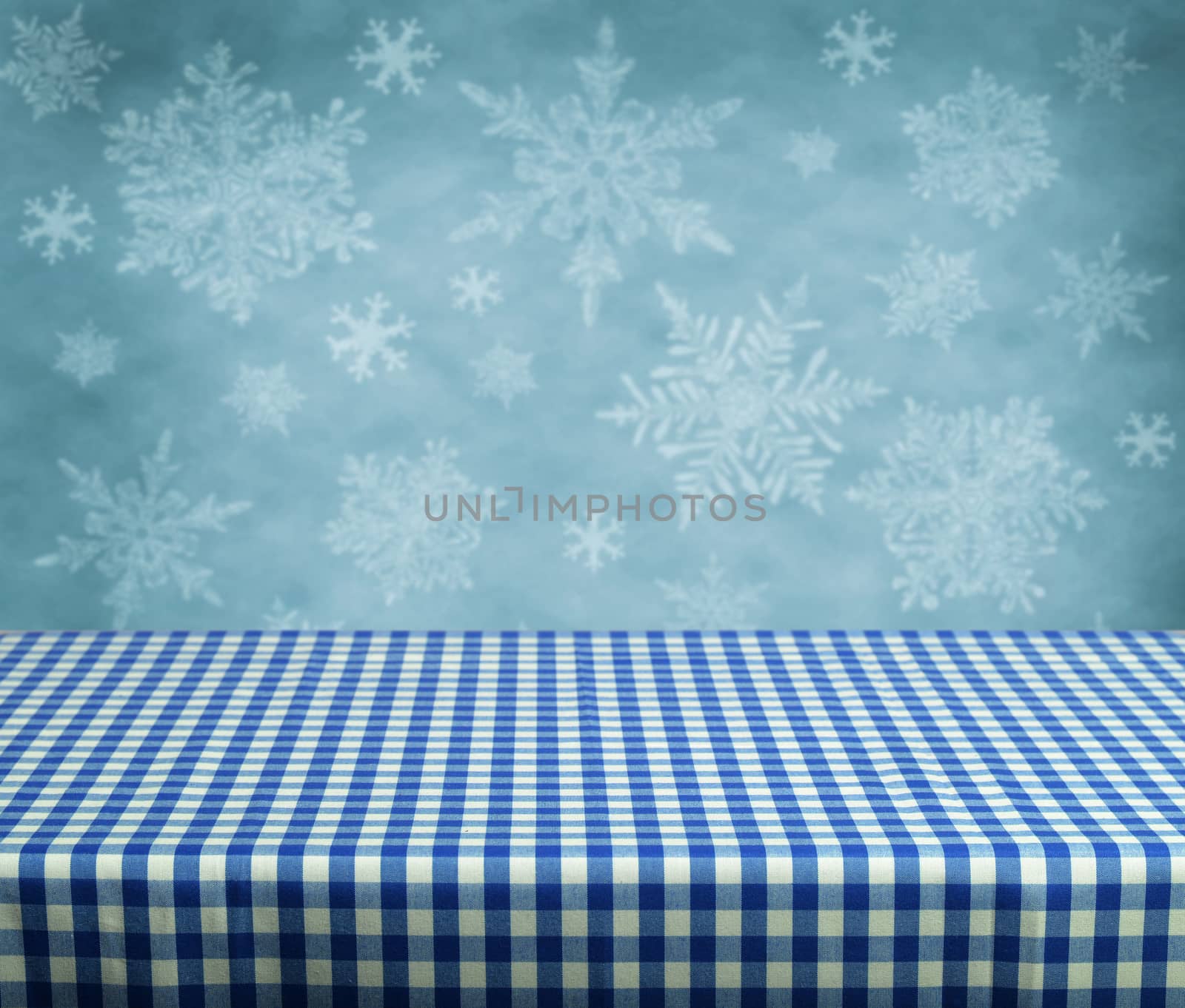 Empty table with blue gingham tablecloth over winter background. Great for product display montages