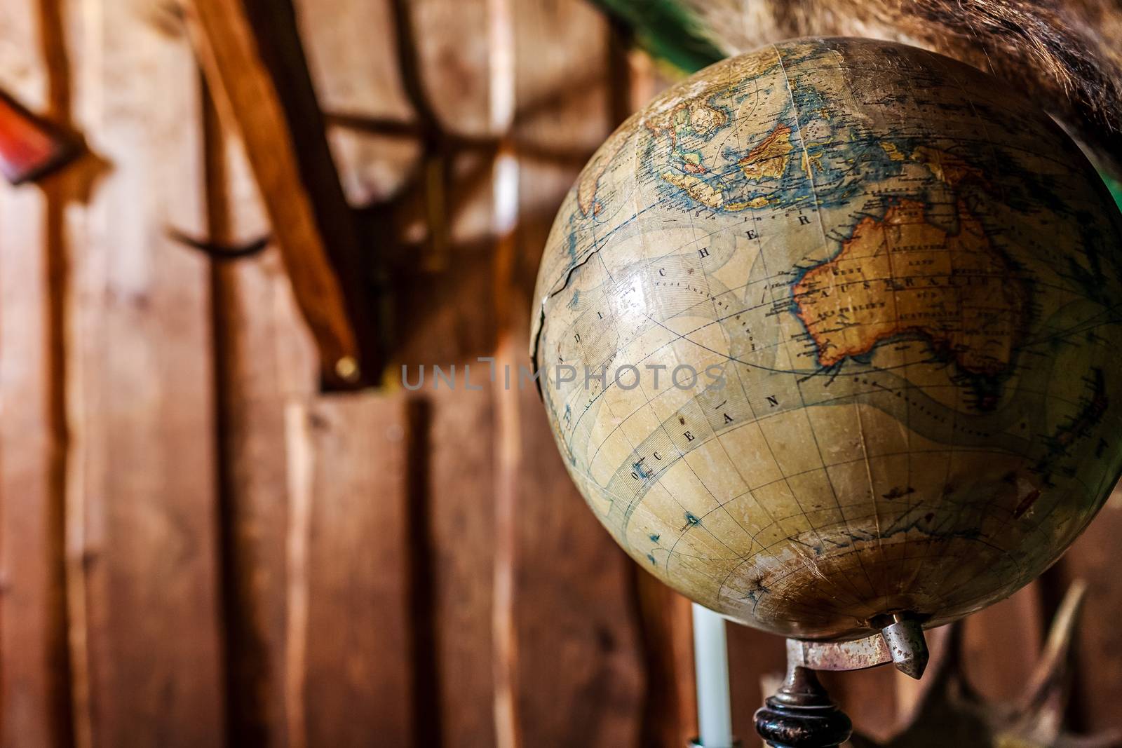 Old damaged globe against wooden wall. by westernstudio